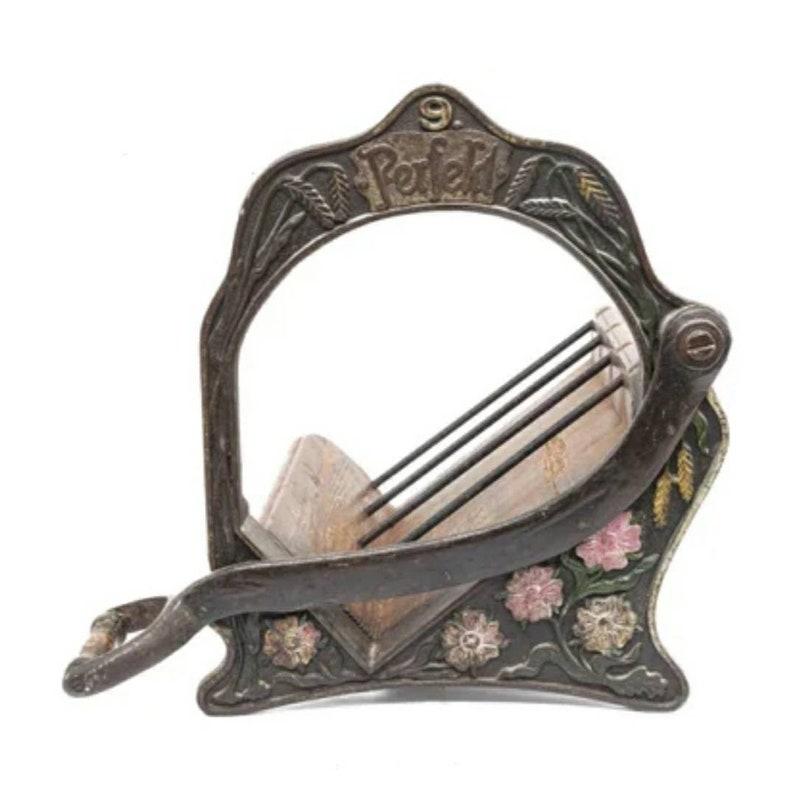 A stunning one-of-a-kind countertop wine rack!

Fashioned from a 19th century cast iron & pine Alexanderwerk German bread cutter / slicer. The blade has been removed for safety. Displays up to four bottles. Original hand painted polychrome floral
