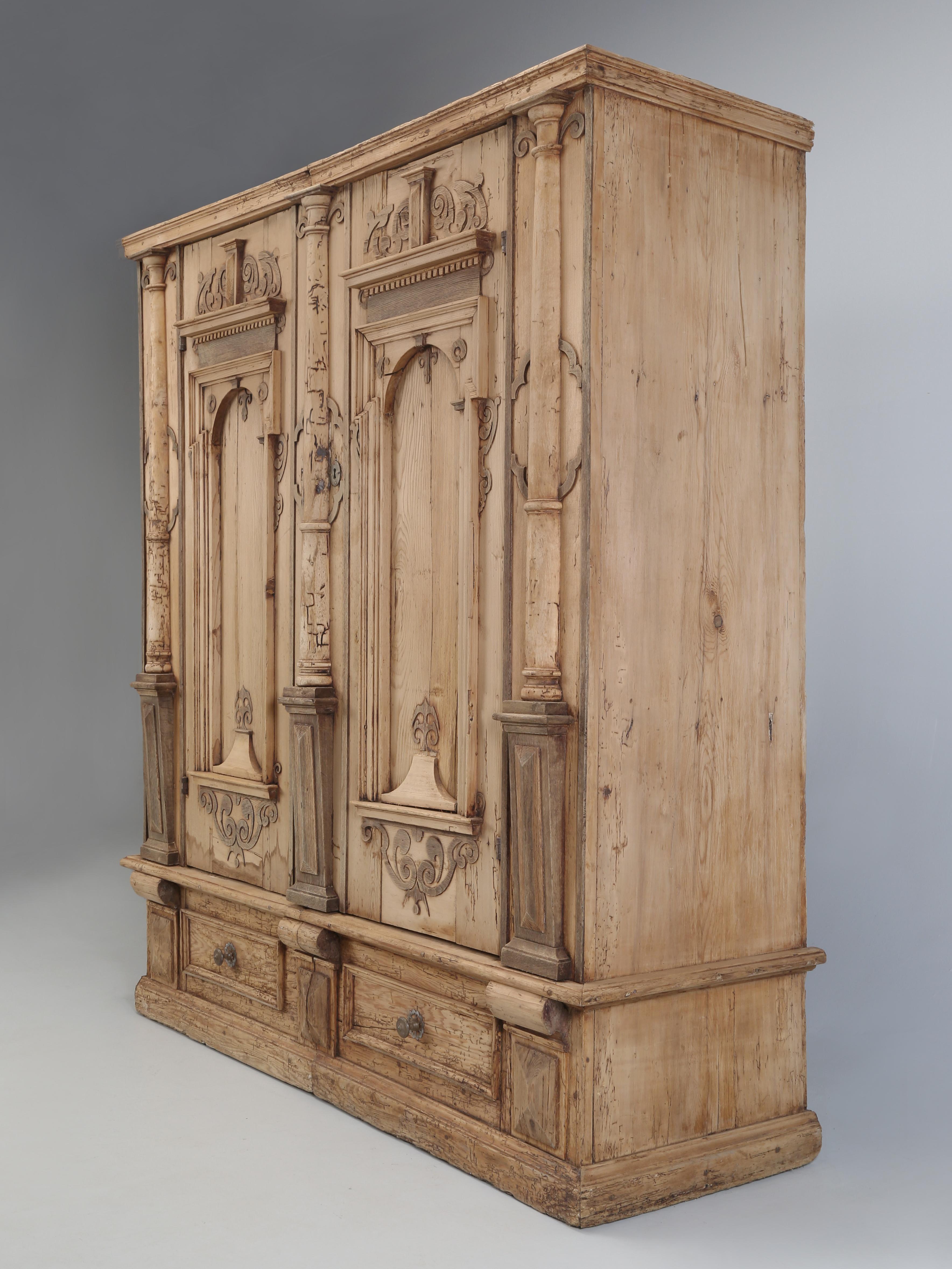Antique German Baroque Armoire or Cabinet with two doors built in the mid-1700’s, based on the hardware and construction. The Antique Armoire is made from Stripped Pine and has numerous interesting details and we were slightly tempted to apply an