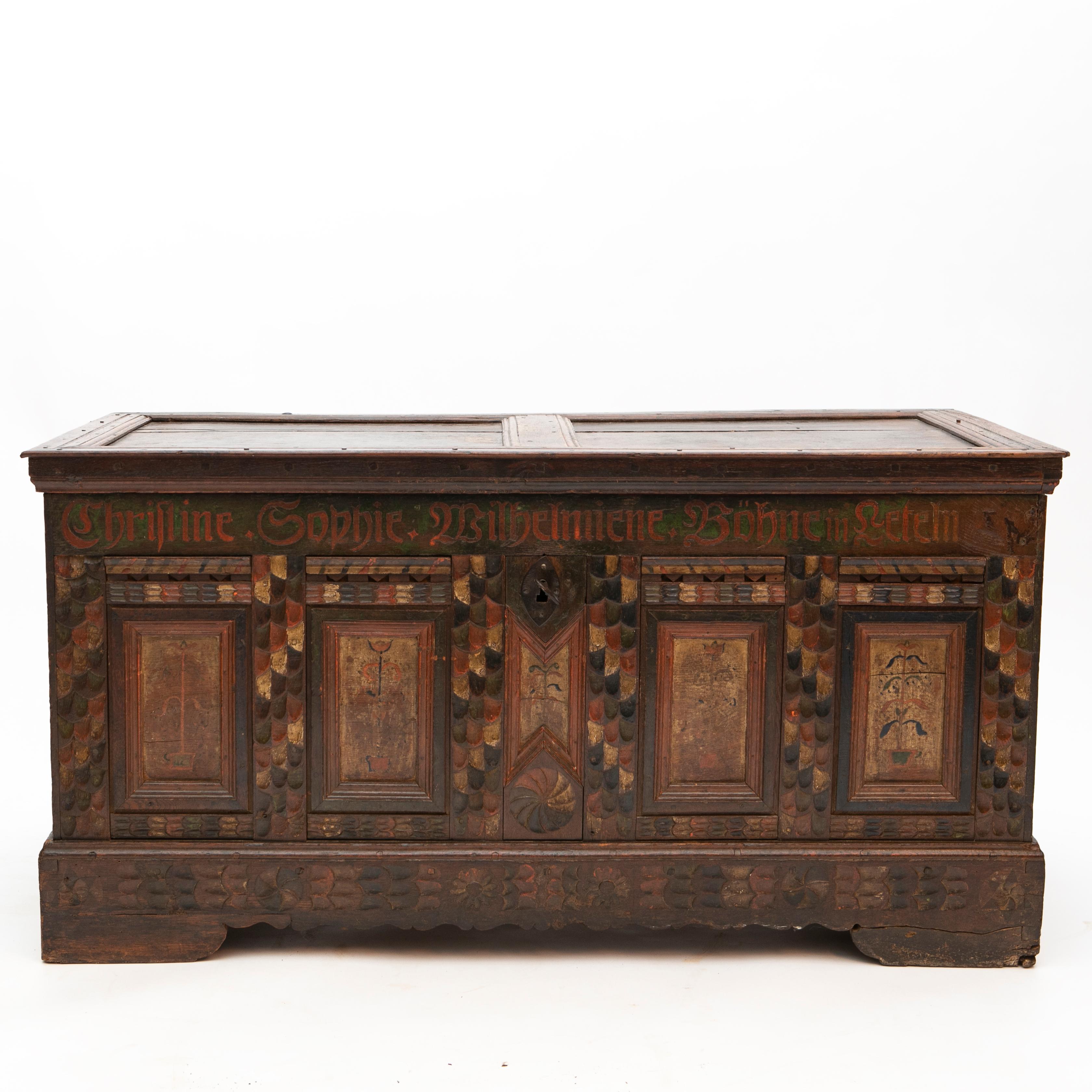 German baroque storage chest or trunk in its original condition.
Hand carved in oak with polychrome hand decorated facade. Top of panel with inscription 