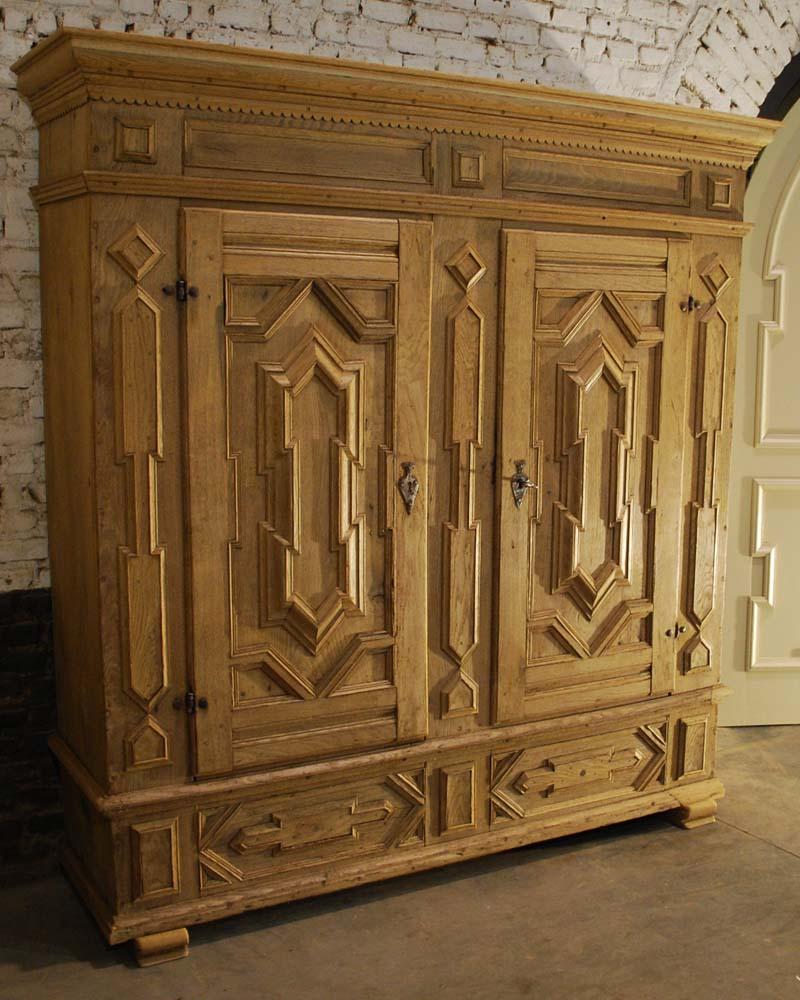 A beautiful 18th century German baroque armoire with two doors. 
Crafted from solid indigenous oak to last for generations, it features intricate geometric design and spacious storage. 
It originates in the region Nortrein Westphalen as a typical