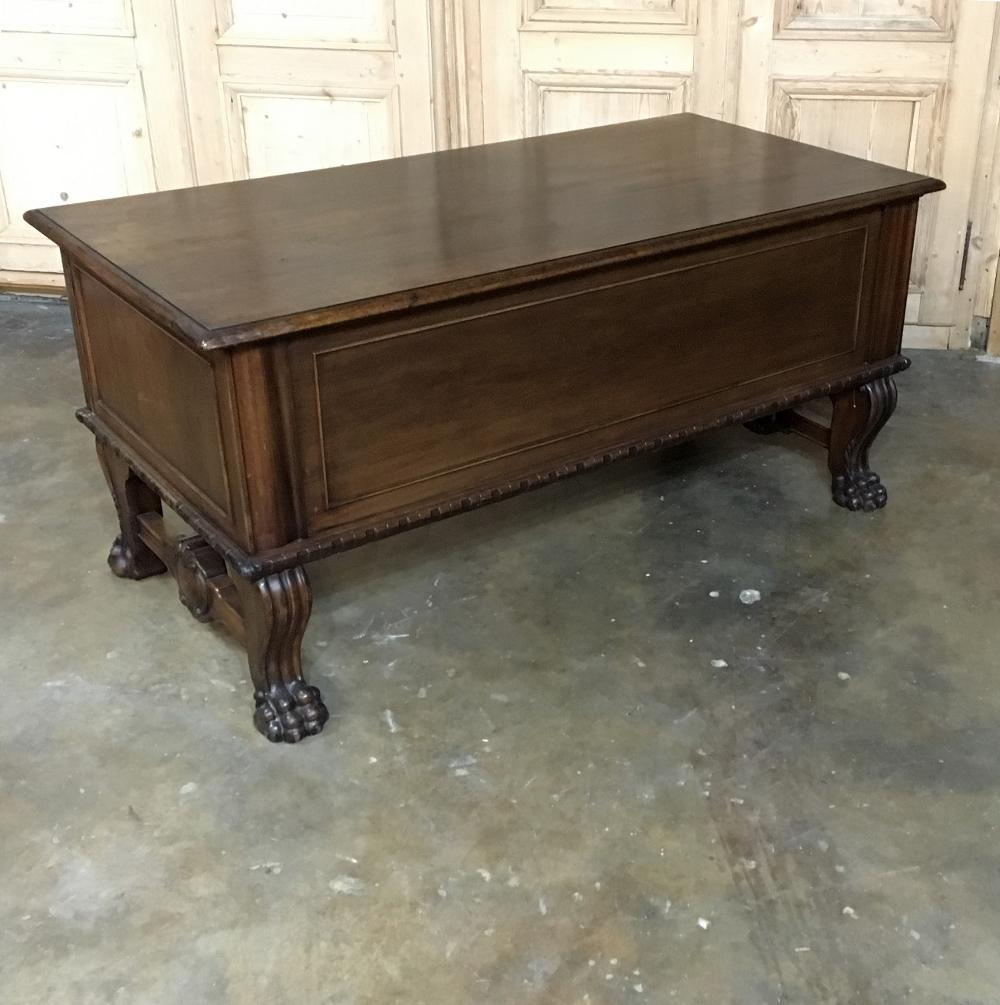 Crafted with pride from solid Walnut, this handsome antique German baroque desk features beautifully scrolled and carved legs with cornerposts carved with classical detailing, highlighting the burl walnut panels of the cabinets. Lions' paw feet on