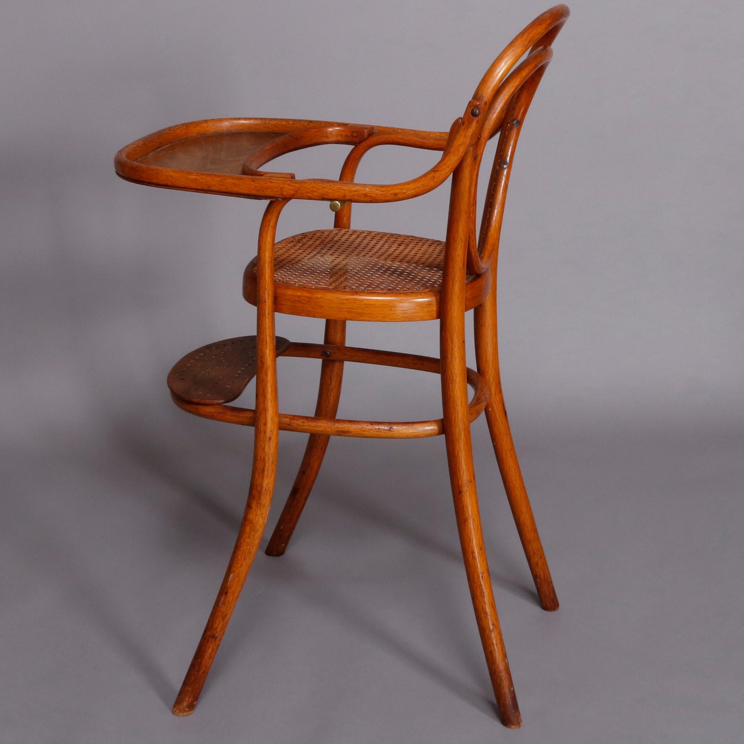 An antique German child's high chair by Michael Thonet offers bentwood construction with caned seat, feeding tray and footrest, original label as photographed, mid-19th century


Measures: 38