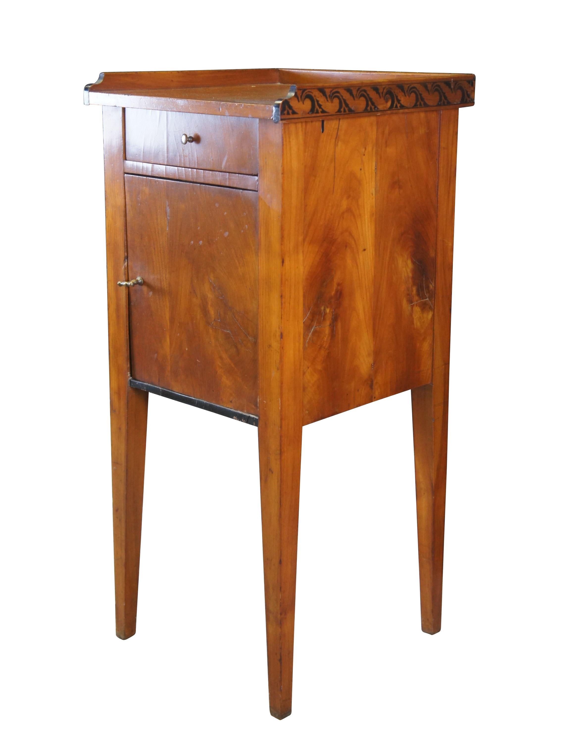 Antique German Biedermeier pillar cabinet or stand.  Made of cherry featuring upper gallery with wavecrest design over one drawer and cabinet, supported by tapered legs.  Circa mid to early 19th century.

Dimensions:
15.75