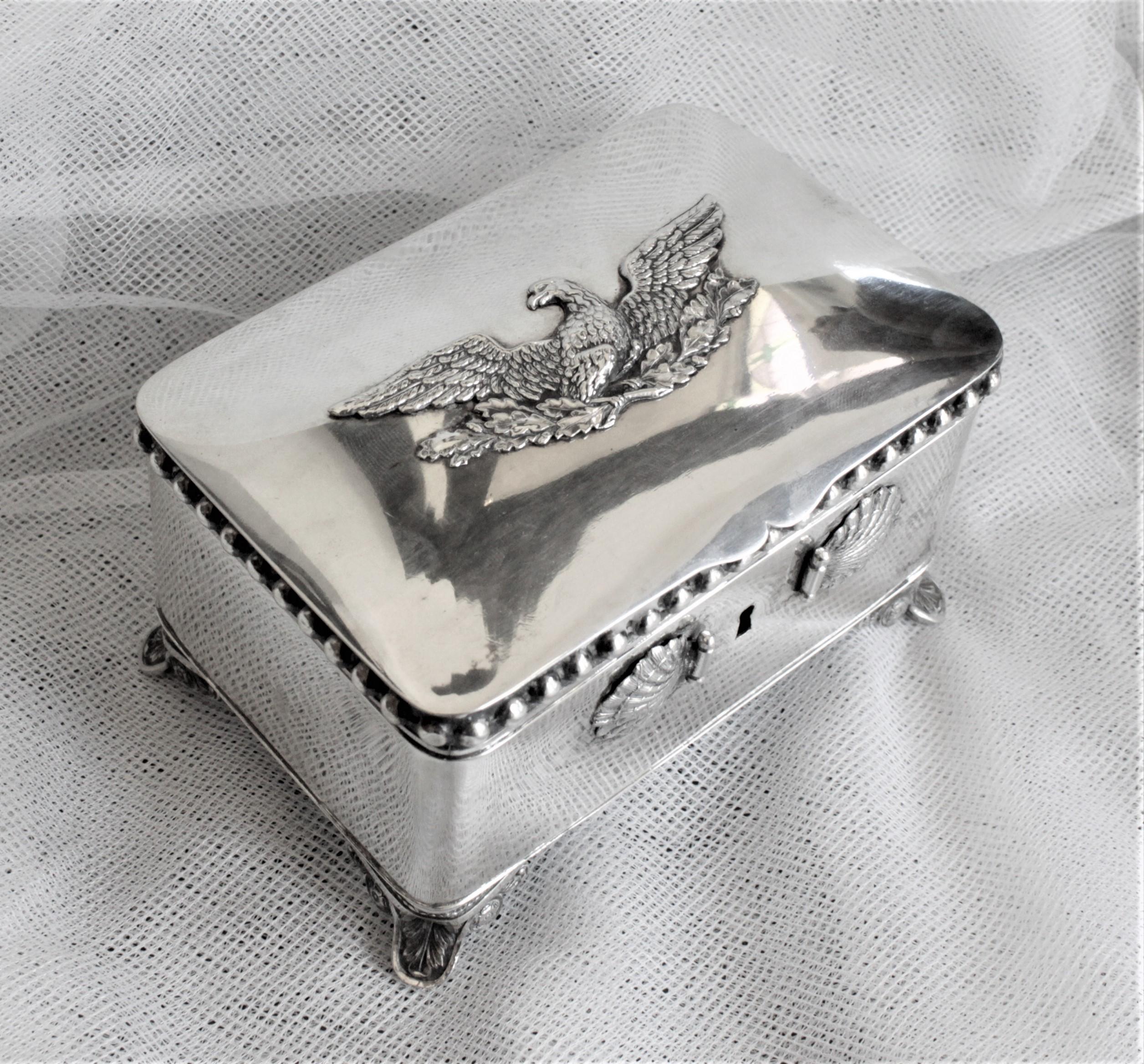 Diese antike deutsche Zuckerdose besteht aus 875er Silber und stammt aus der Zeit um 1850 im Biedermeier-Stil. Das Kästchen steht auf kunstvoll gearbeiteten Füßen und weist ein Muschelrelief auf, das die Vorderseite des Kästchens ziert, und obenauf