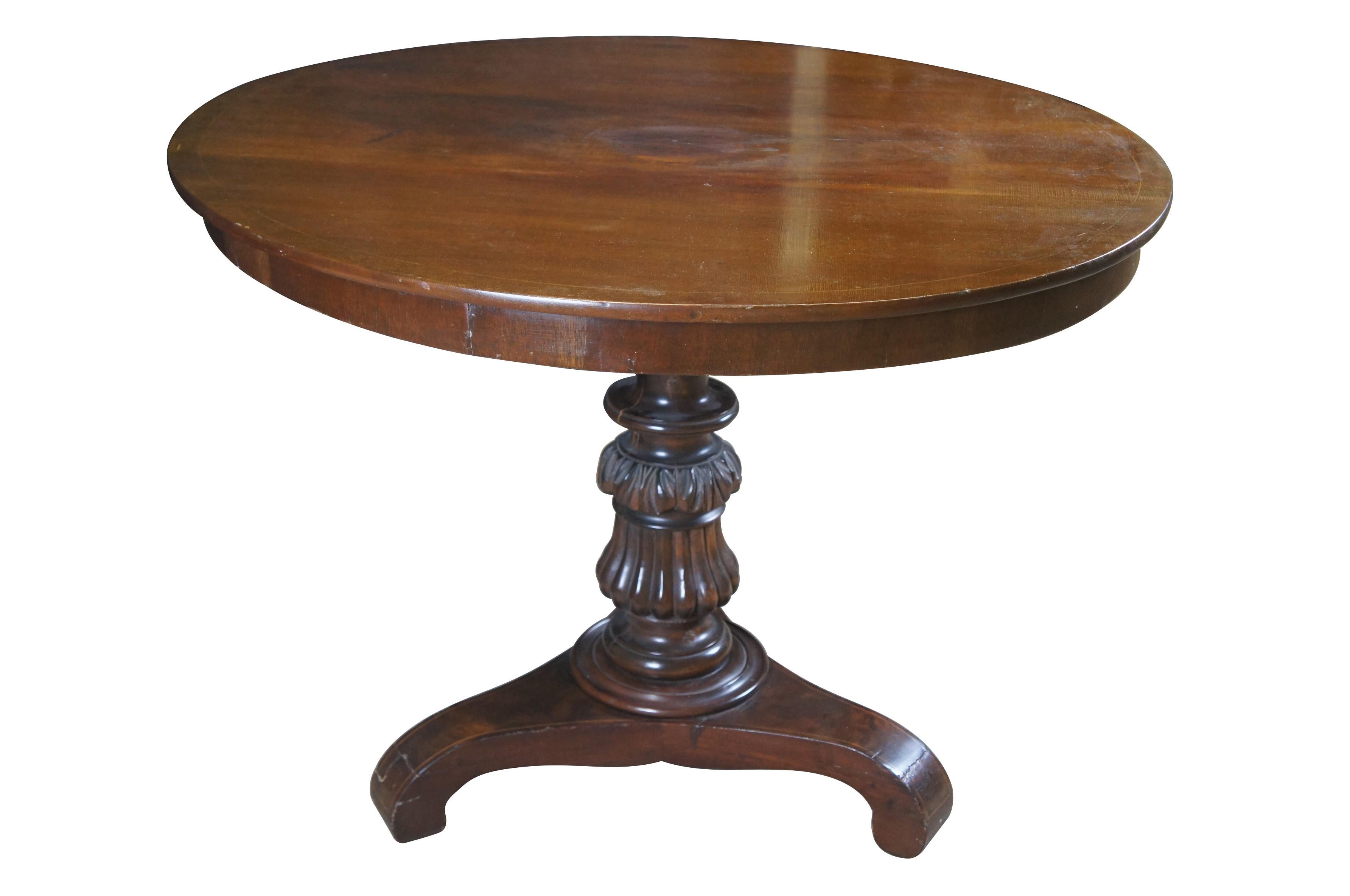 Antique early 19th century German Biedermeier period mahogany centre  / breakfast table featuring round form with inlaid fruitwood design supported by a turned and carved column on triangular base.  Circa 1830s.

From 1815-1848, Northern European