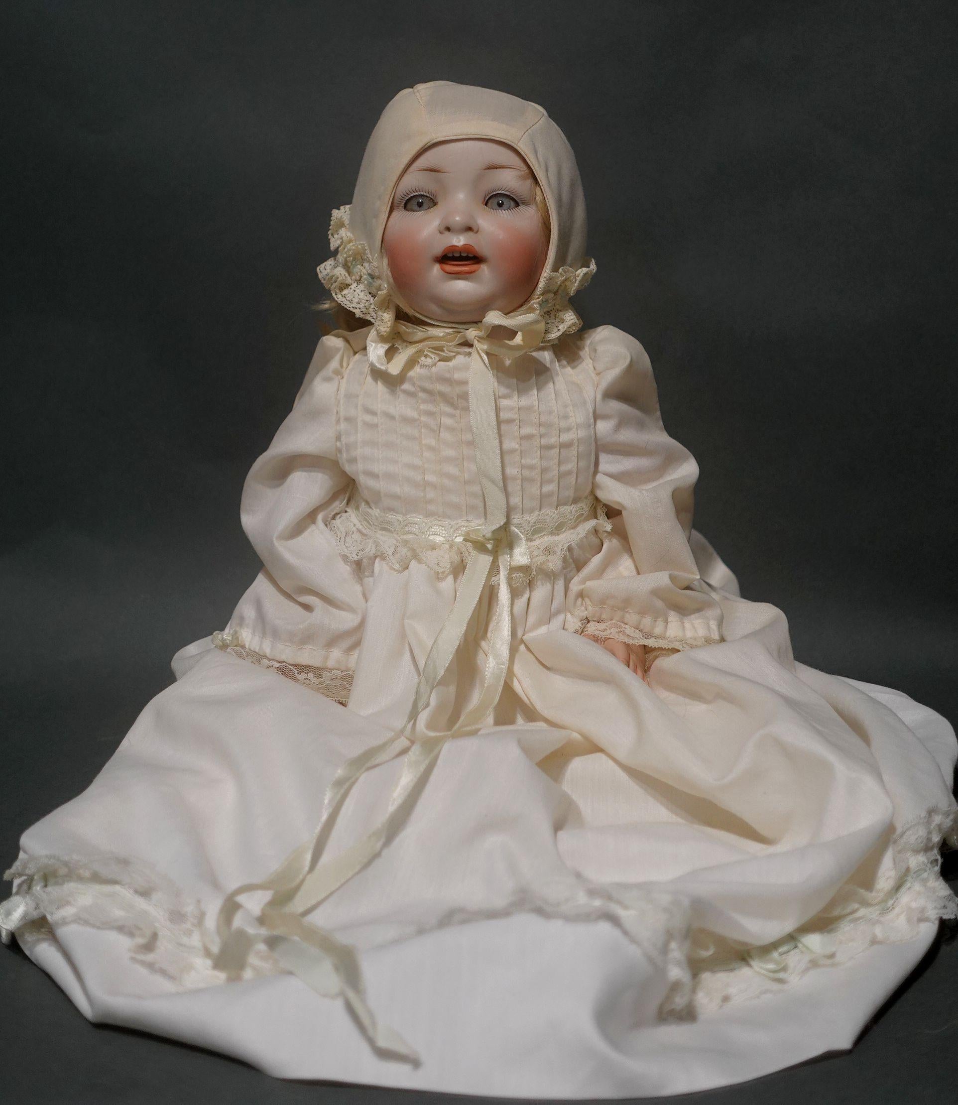 Antique Hertel Schwab baby doll 152/6 for Louis Wolf & Company. Measures approximately 15 inches in height. Beautiful blue glass sleep eyes with painted upper and lower lashes. Painted eyebrows. Open mouth with four insert upper teeth and a bisque