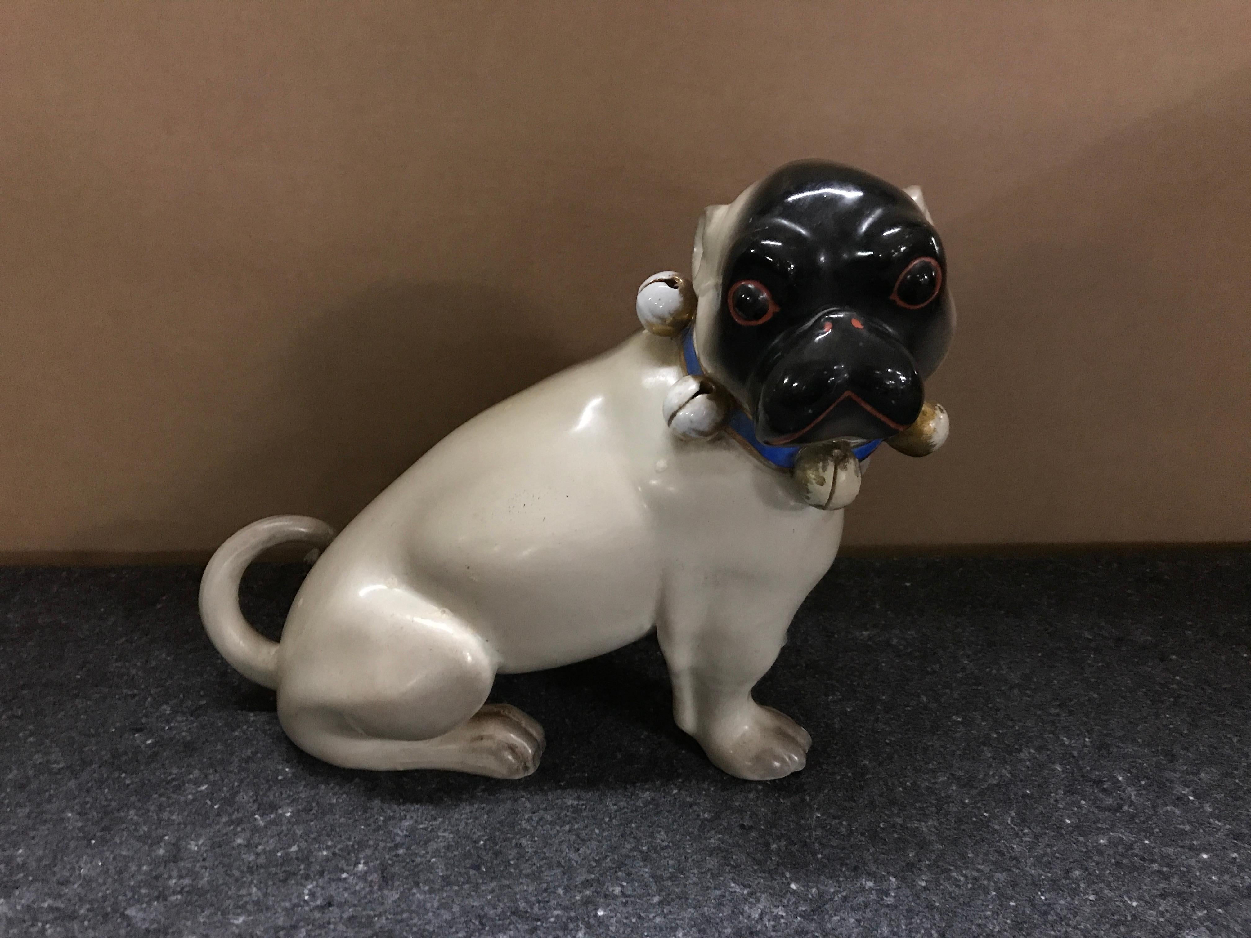 Antique German black faced seated pug dog, unusual large size, with bell collar with a blue ribbon 
Measures: 8.75