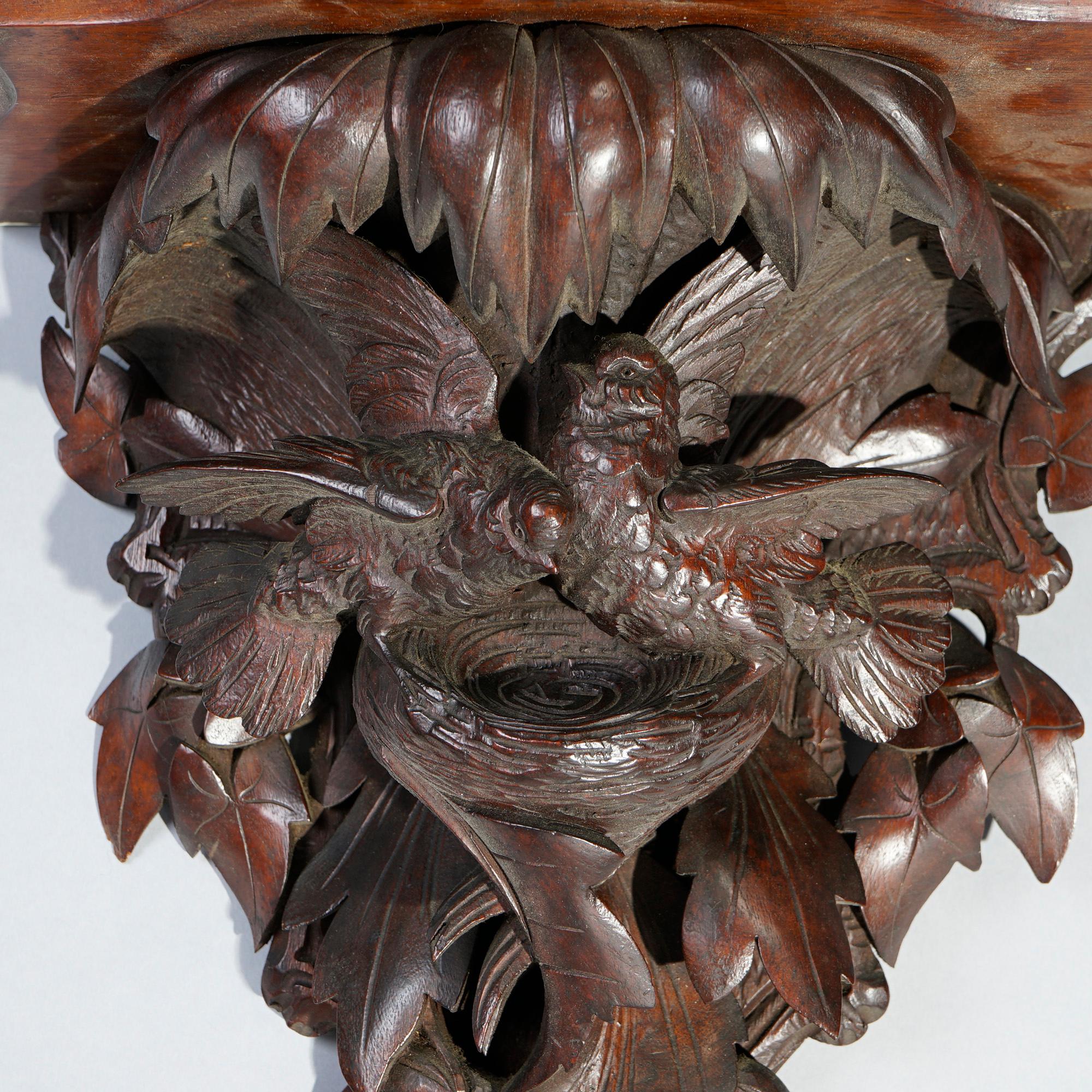 An antique German Black Forest figural wall shelf offers shaped display over carved birds and nest in foliate setting, c1890

Measures- 18''H x 17.5''W x 11''D