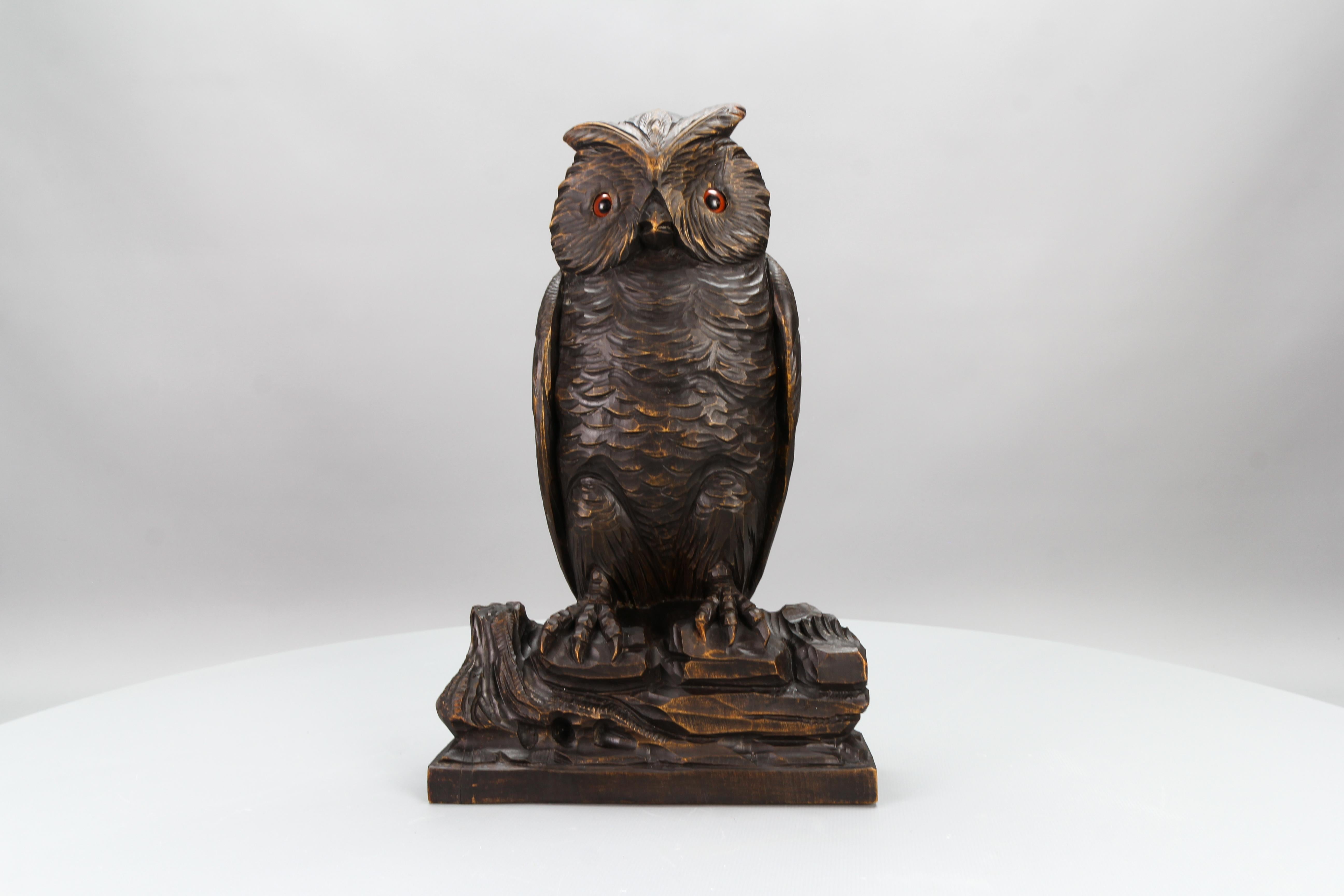 An antique Black Forest style hand-carved Lindenwood owl sculpture, Germany, circa 1920.
This impressive naturalistically carved dark brown wooden owl with glass eyes, sitting on a wood, would be a great eye-catcher in any room or