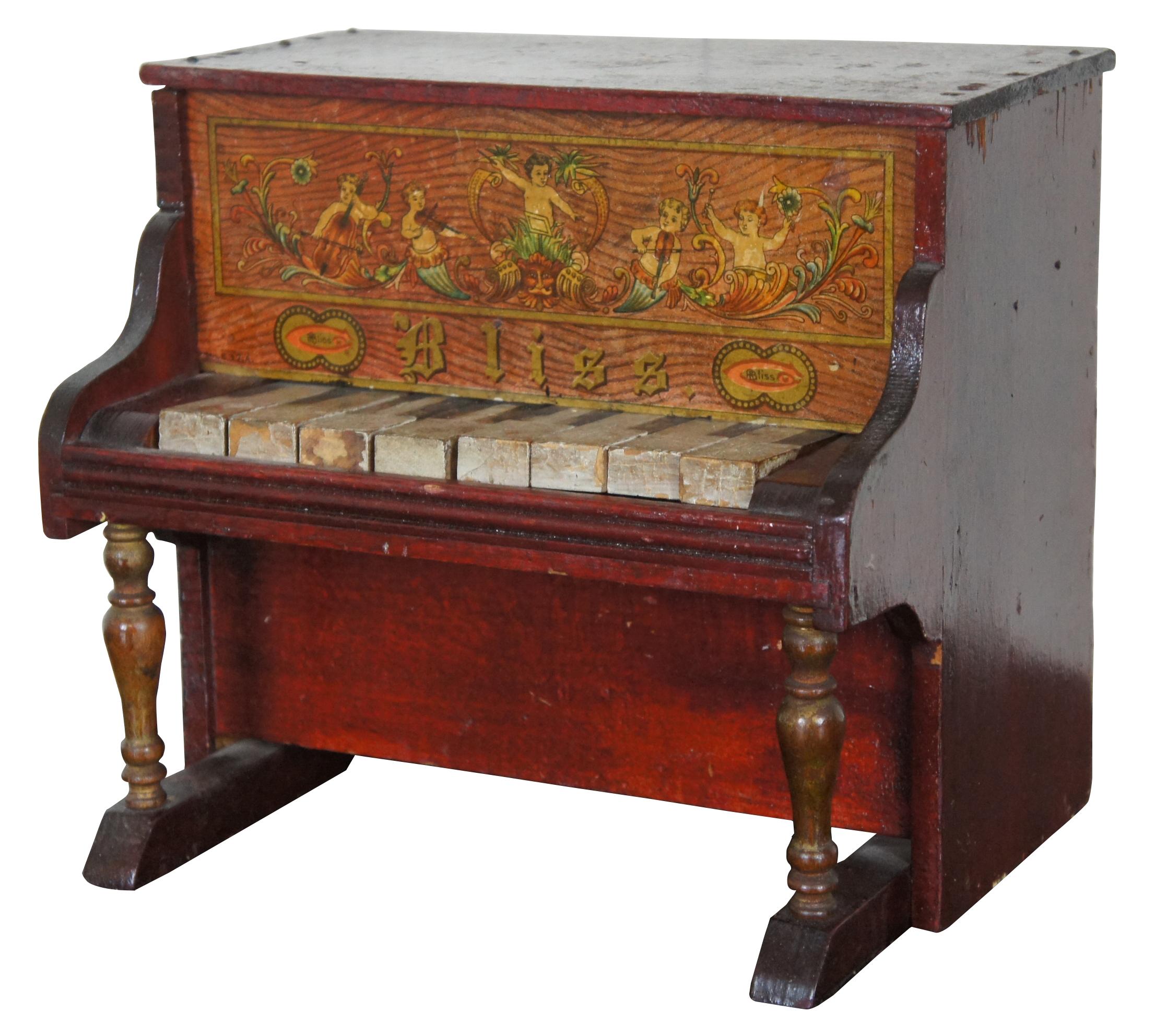 Antique wooden toy upright piano by Bliss with lithograph print featuring an orchestra of cherubs. Eight working wooden keys that strike on a miniature glockenspiel inside.
  