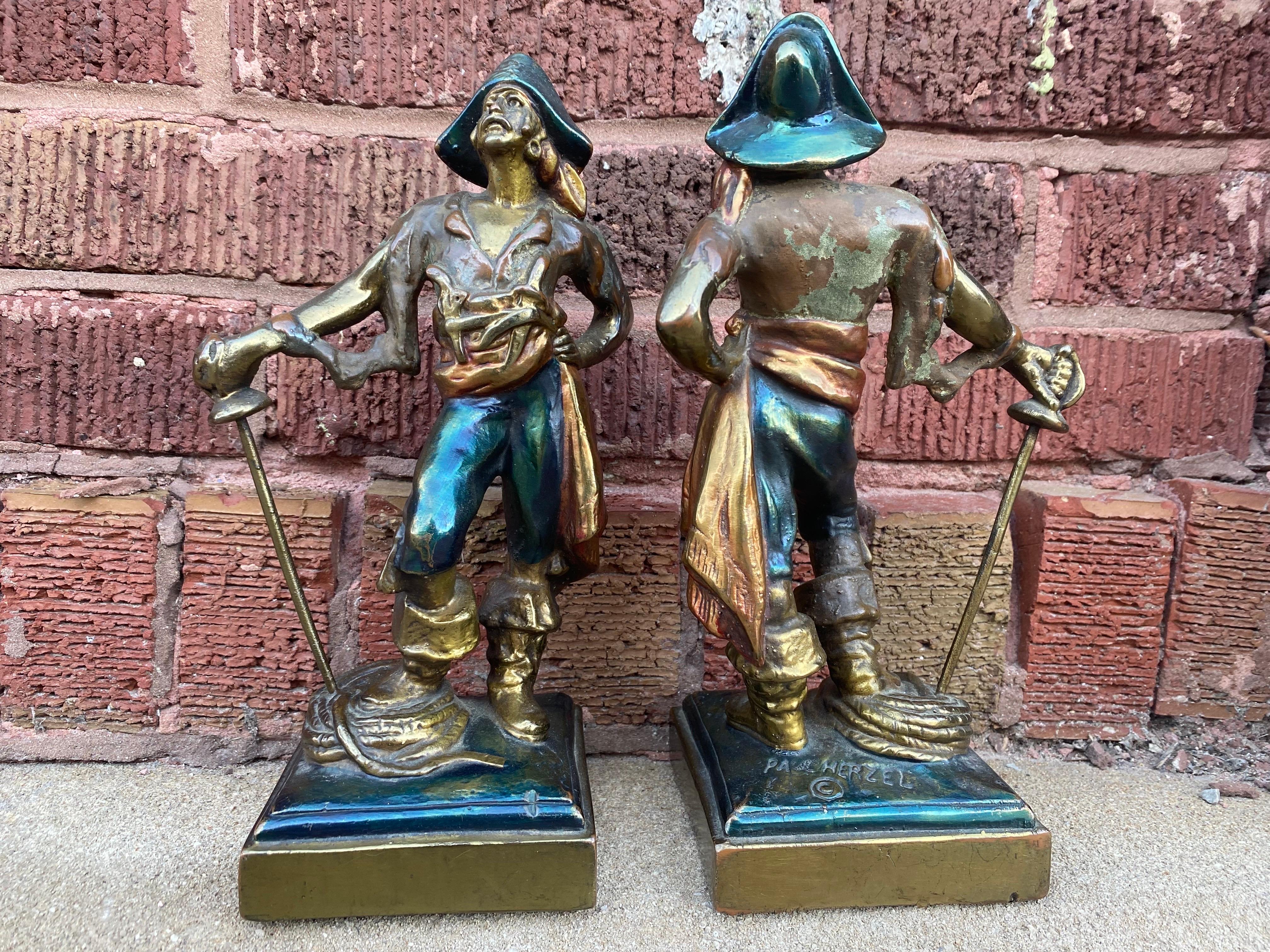 Antique German Bronze Pirate Bookends Signed by Paul Herzel

Two pirates stand proudly, their swords planted in the ground and their hands on their hips. They don pirate hats and have a gun and knife holstered to their chests. Each has Paul Herzel's