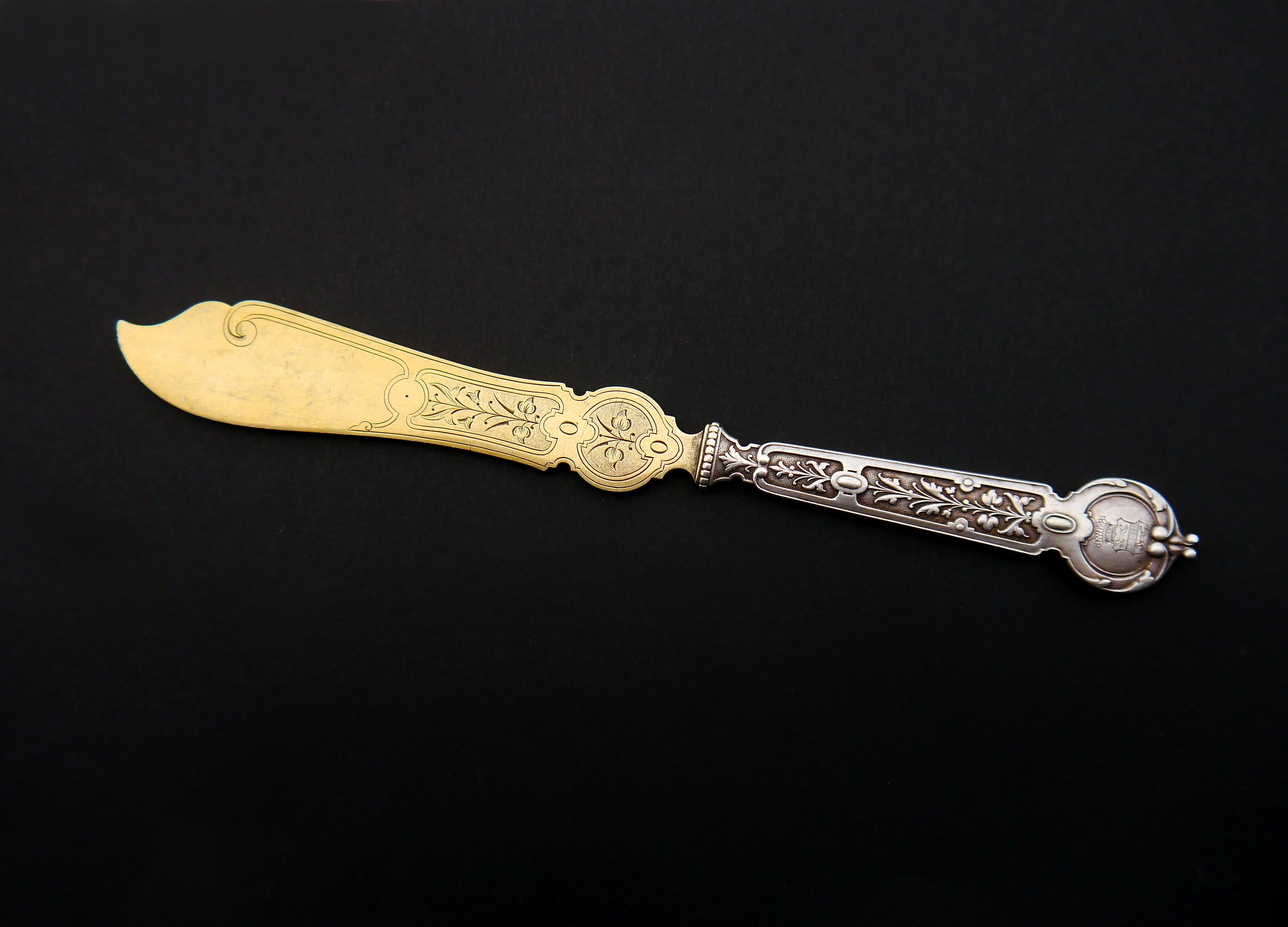 This is a German butter knife of fancy design with hand-engraved ornament on a Gilt blade and a richly decorated handle.
Made ca. 1900 -1920s it has hallmarks of M.H . Wilkens - a famous German maker of fine Silver from Bremen. There is a
