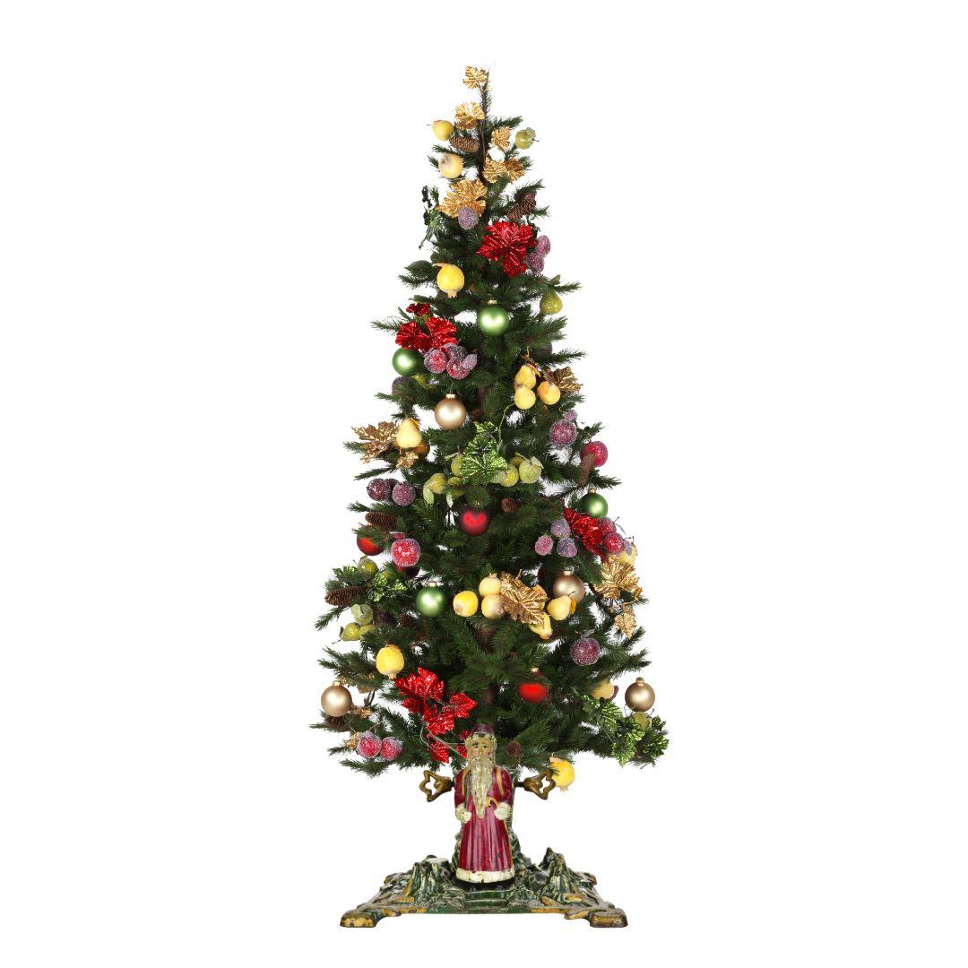 This charming antique German cast iron Christmas tree stand features a beautifully hand-painted Santa Claus figure in vivid red and white, set against a detailed green landscape base with golden accents. 
The stand showcases a winter forest motif,