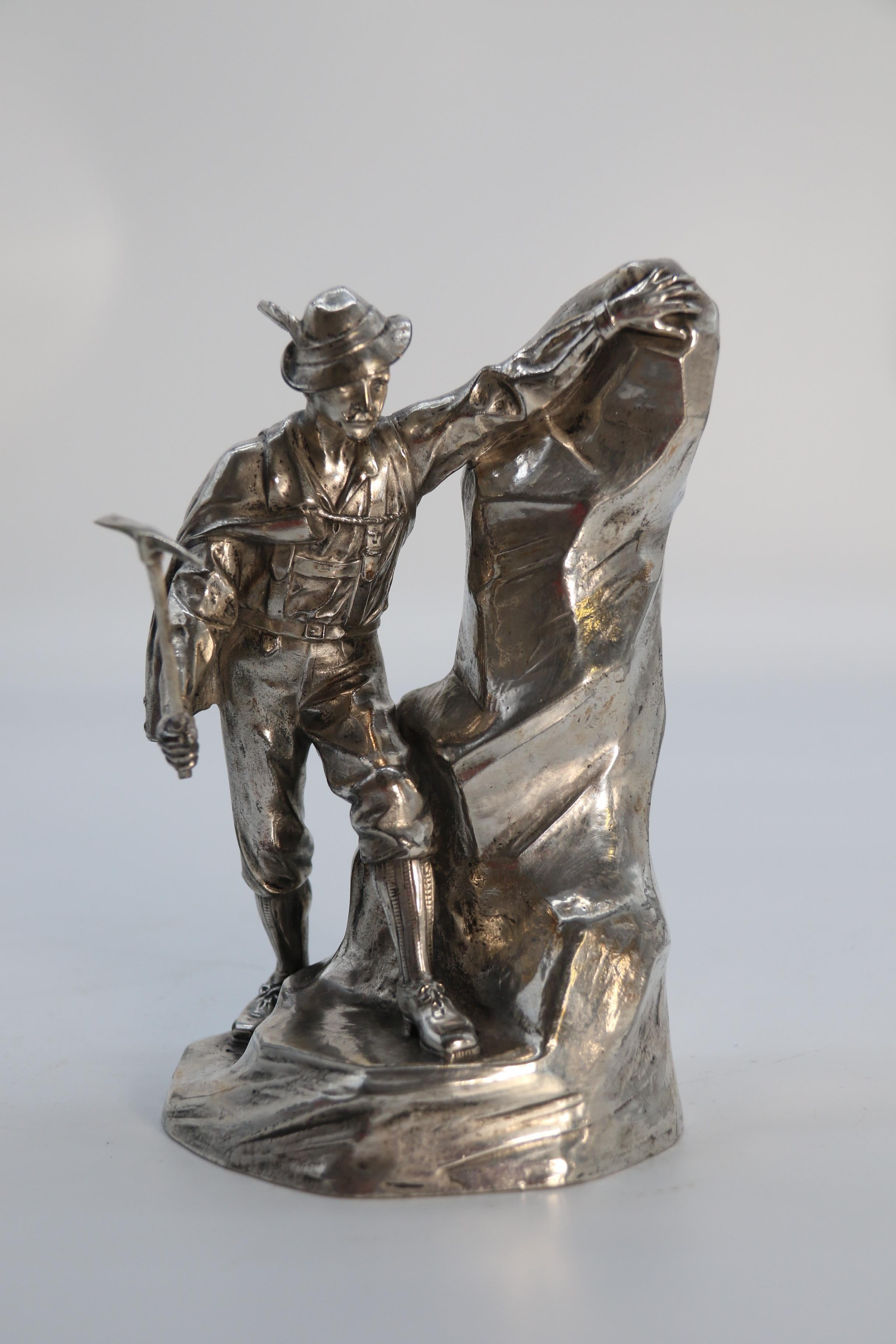 This fine quality stamped WMF silver plated sculpture is a rare and most interesting subject. It depicts an early European exploring mountaineer dressed in smart early 20th century country climbing attire. He is modelled holding a climbing pick axe