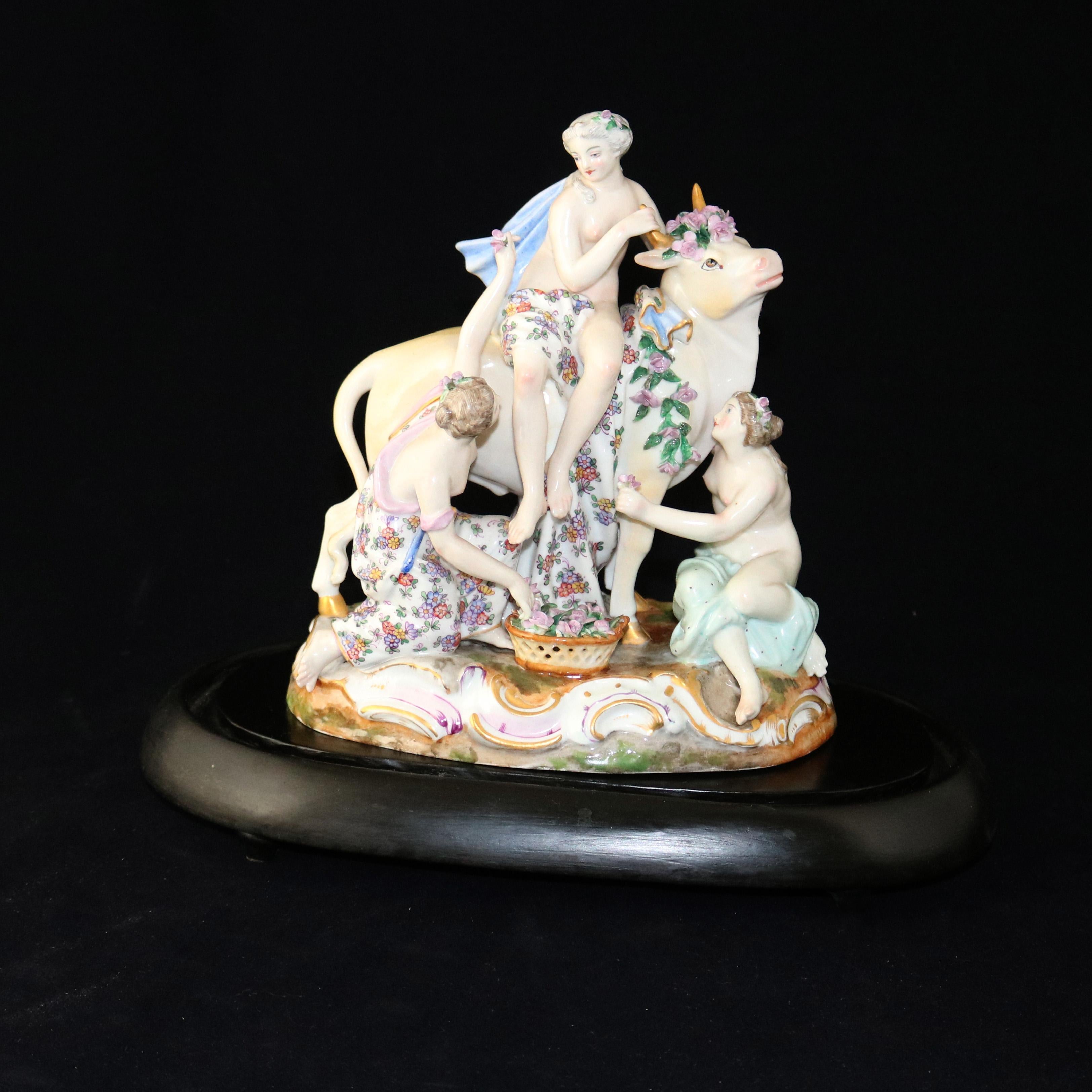 An antique German Meissen School hand painted and gilt porcelain Classical Greek figural group Europa depicts a decorated bull and three muses in a flower garden setting, maker mark on base as photographed, includes display of wood base and glass