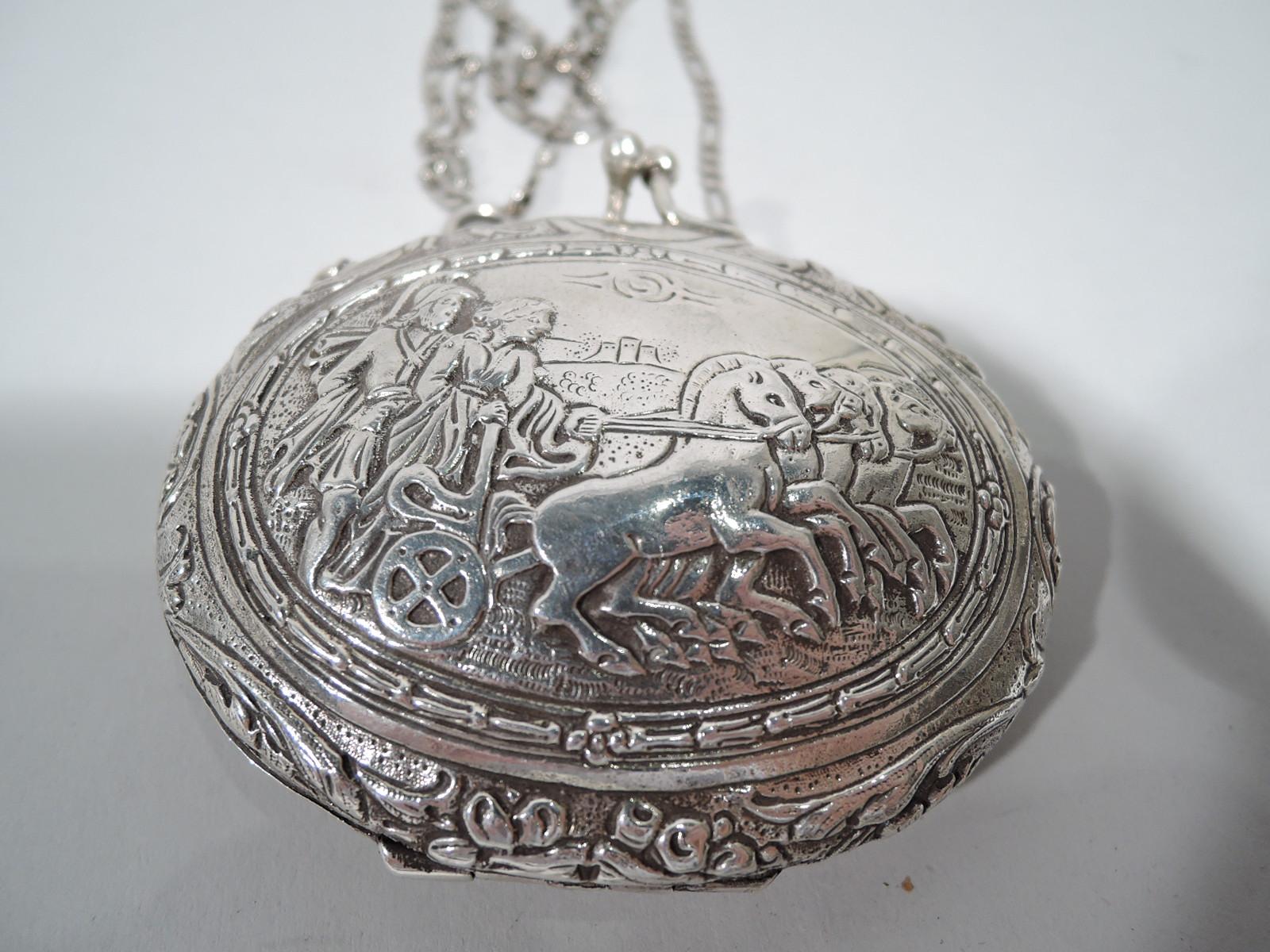 German Classical 800 silver coin purse, ca 1910. Oval and hinged. On front a man in Roman helmet guides a woman who holds the reins of horse-drawn chariot. On back is strapwork cartouche (vacant). Ornament is chased and tooled. Interior velvet