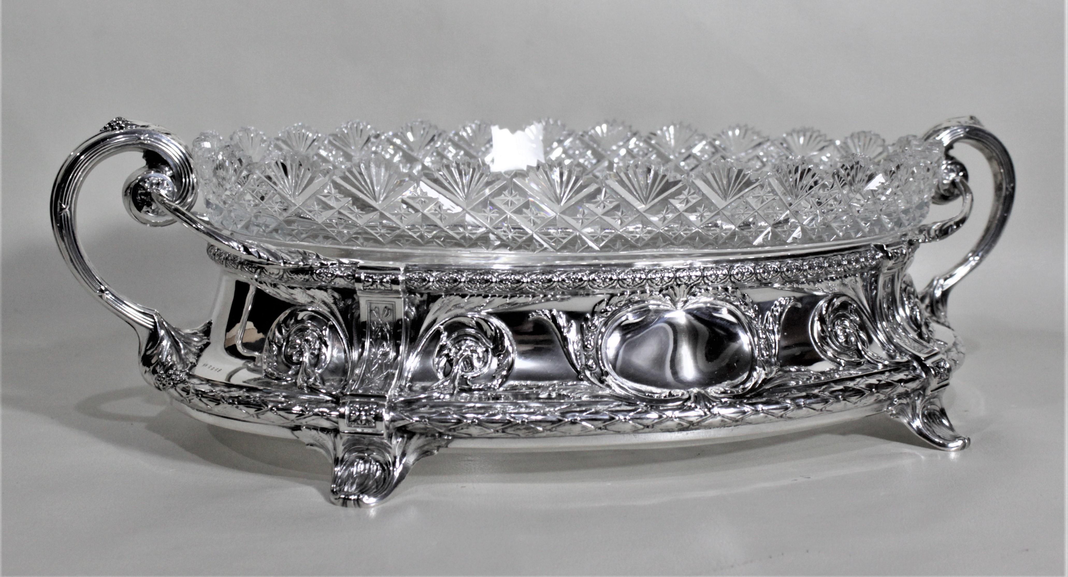 This antique German Continental silver and cut crystal centerpiece does have a maker's mark, but quite illegible so the maker is being regarded as 'Unknown'. This very ornately cast silver footed base is decorated with elaborate scrolling repousse