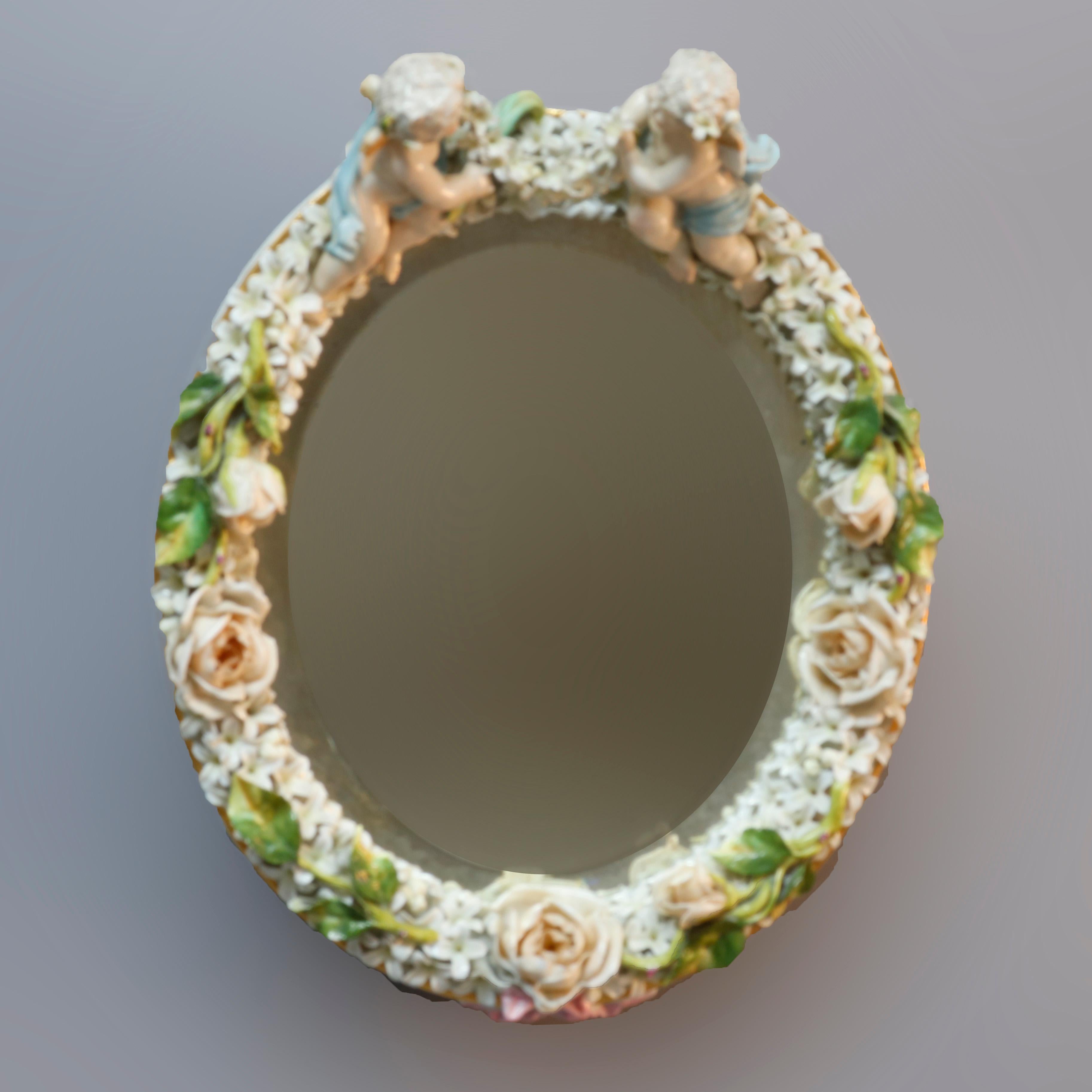 An antique German Dresden figural wall mirror features porcelain construction with playful Classical cherubs at crest and flowers throughout, 19th century

Measures: 12.75