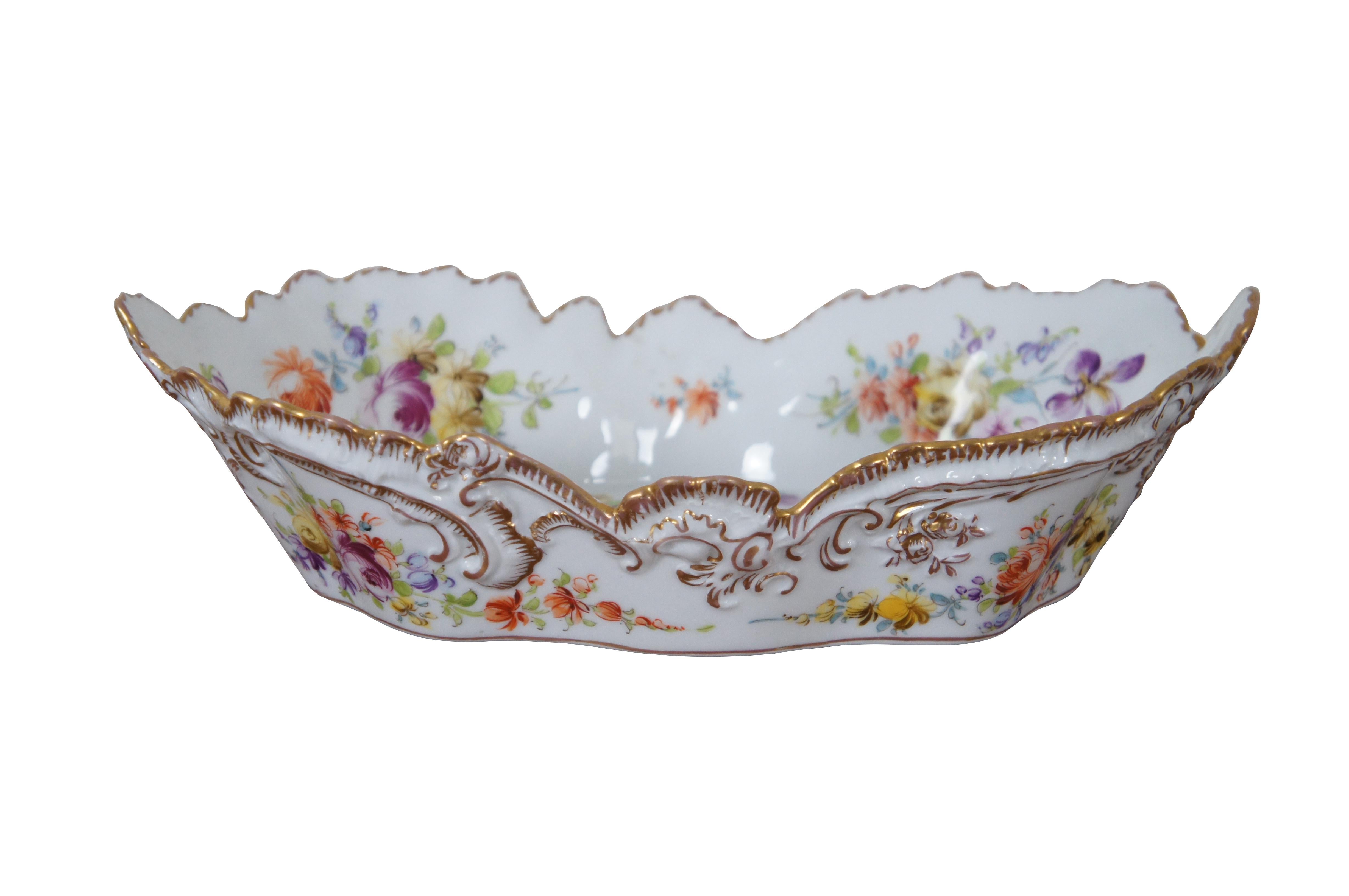 Antique German Dresden crown H mark centerpiece bowl or serving compote.  Made of porcelain featuring scalloped oval form with floral design and gold accents.  

Attributed to Adolf Hamman, located in the Serrestrasse 8 and founded in 1866. The