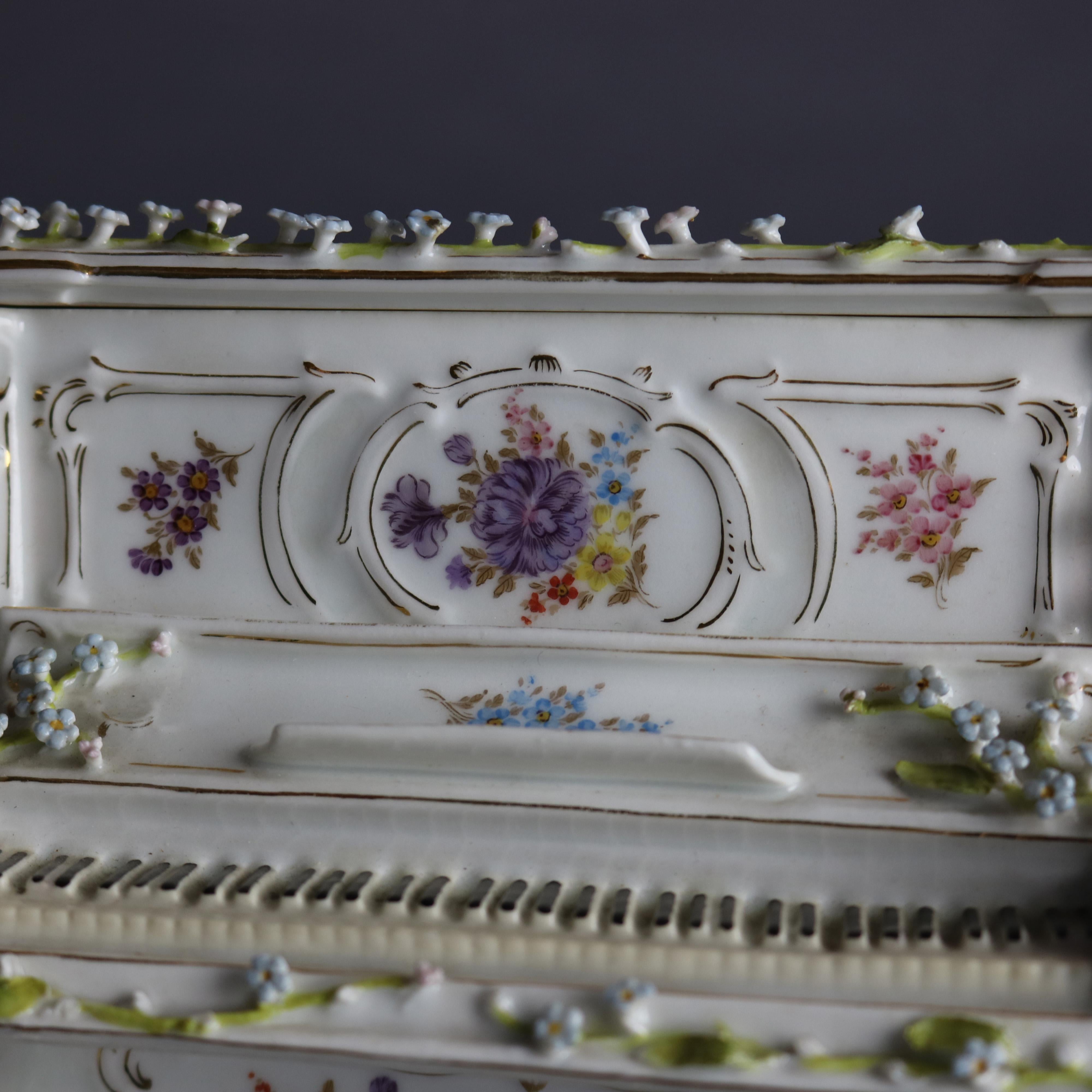 An antique German Dresden dresser box offers porcelain construction in piano form with hand painted and applied flowers throughout, marked on base as photographed, 19th century

Measures: 5.75