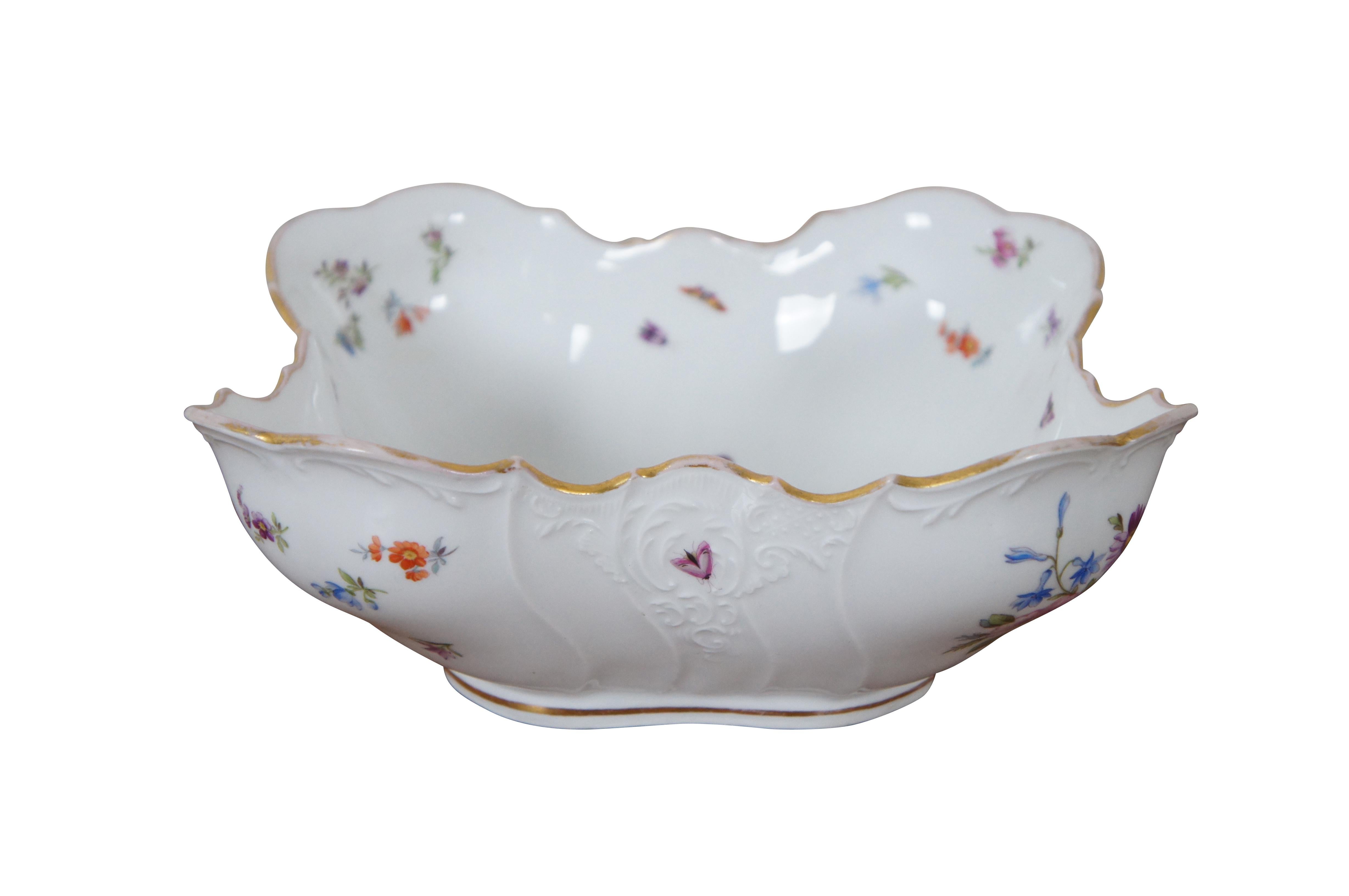 Antique German Dresden porcelain serving bowl or compote featuring square form with serpentine ruffled edge design, gold trim, flowers and insects (butterflies, ladybugs, moths).


DIMENSIONS
9” x 8.5” x 3.5” (Width x Depth x Height)