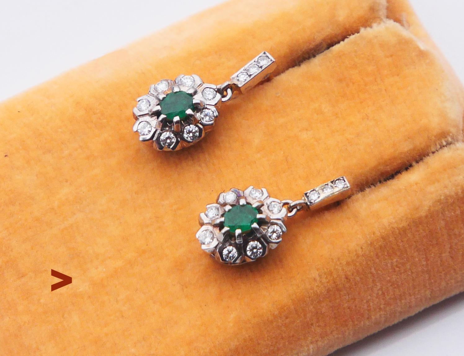 A pair of fine flower halos featuring natural Emeralds and Diamonds in solid 18K White Gold settings.
Stoppers hallmarked 750. Likely German hand-made ca. 1920s - 1930s. 

Each earring is 18 mm long. Florets : 11mm x 8mm x 5.5 mm deep.

Two oval cut