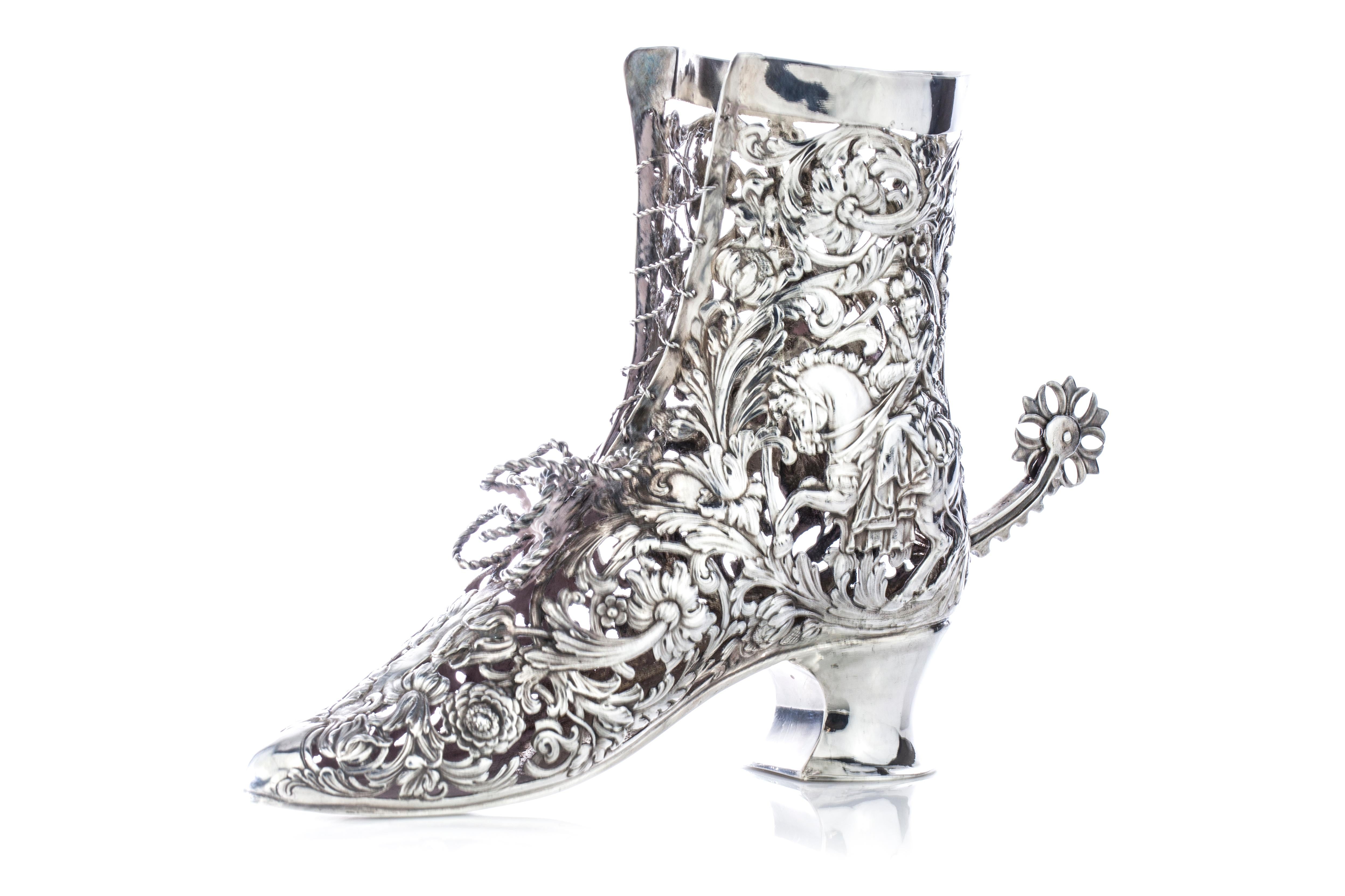 Antique German Hanau silver vase in a shape of a shoe

Please note no glass liner.
Made in Germany, 19th century
Imported to Scotland, Glasgow, 1903
Maker: B. Neresheimer & Sohne
Fully hallmarked.

B. Neresheimer & Sohne, Hanau
Founded