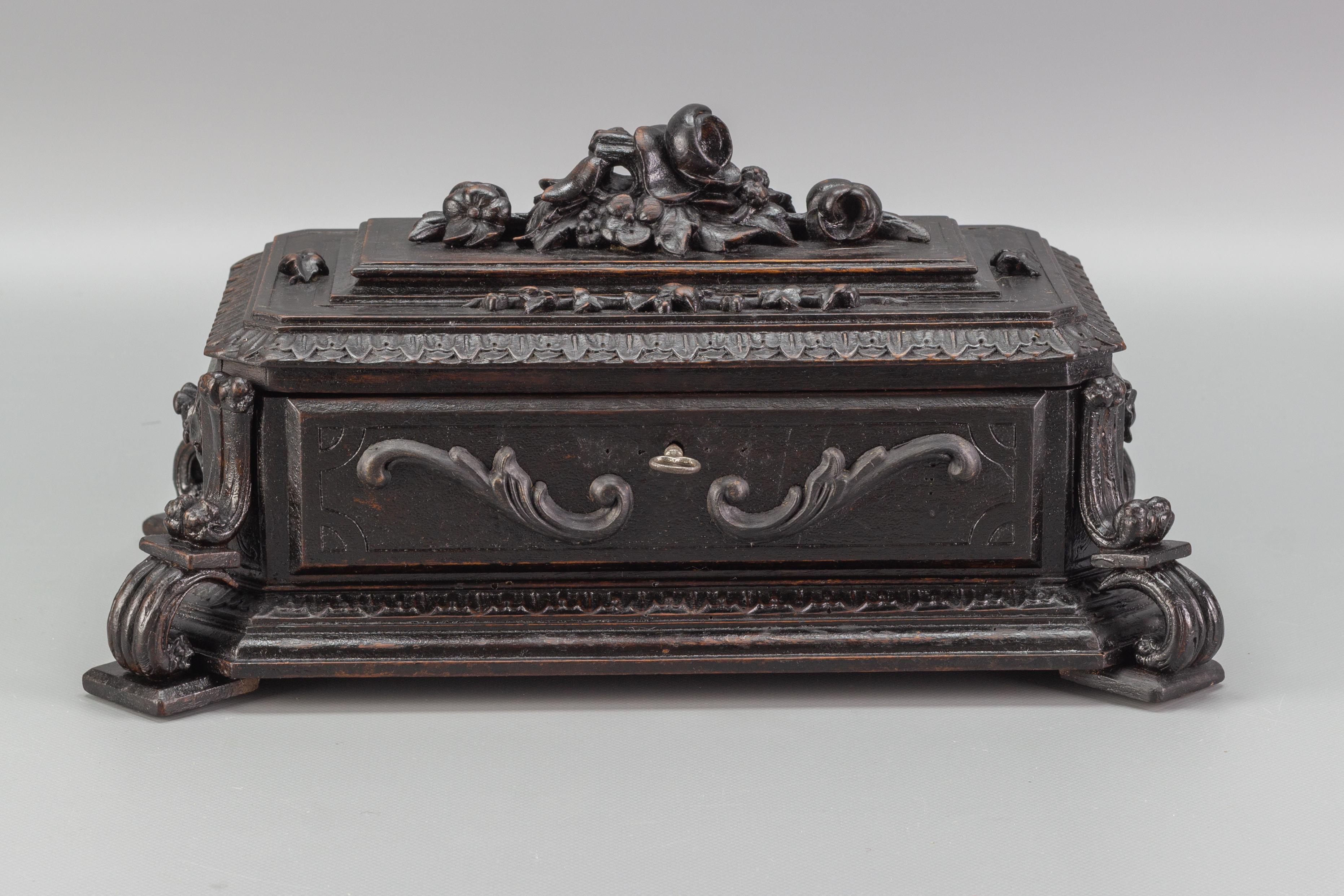 A beautiful hand-carved wooden jewelry box with a green velvet interior and key, Germany, circa 1900. Masterfully carved floral top and carved leaves on the edge of the lid. Adorned with floral carvings on sides and decorative corners.
Dimensions: