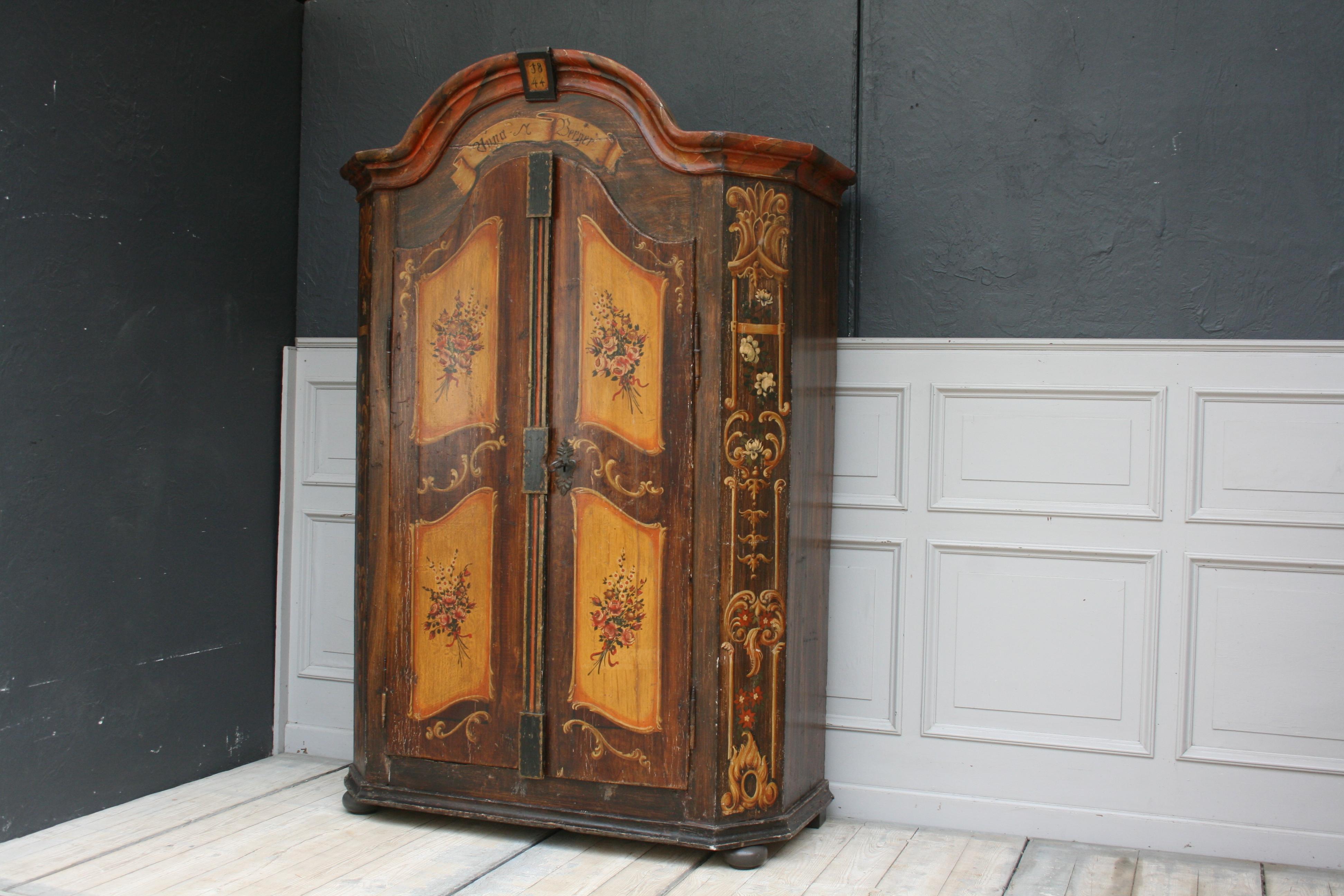 Antique hand painted Armoire from southern Germany with chamfered corners and a curved bonnet.
The hand painted number in the top indicates the date of manufacture of the cabinet, in 1844.
The 2 doors are hung with external hinges and can be
