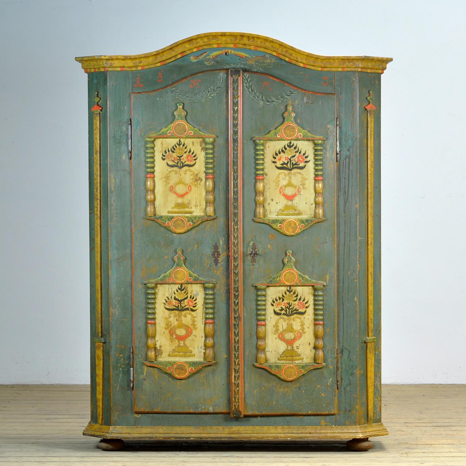 A pine cupboard from rural southern Germany, dating from 1803. The cupboard was probably given as a wedding gift. This cabinet is made of solid pine and is hand-painted in vibrant colors. The relief on the doors and sides is striking. The cabinet is