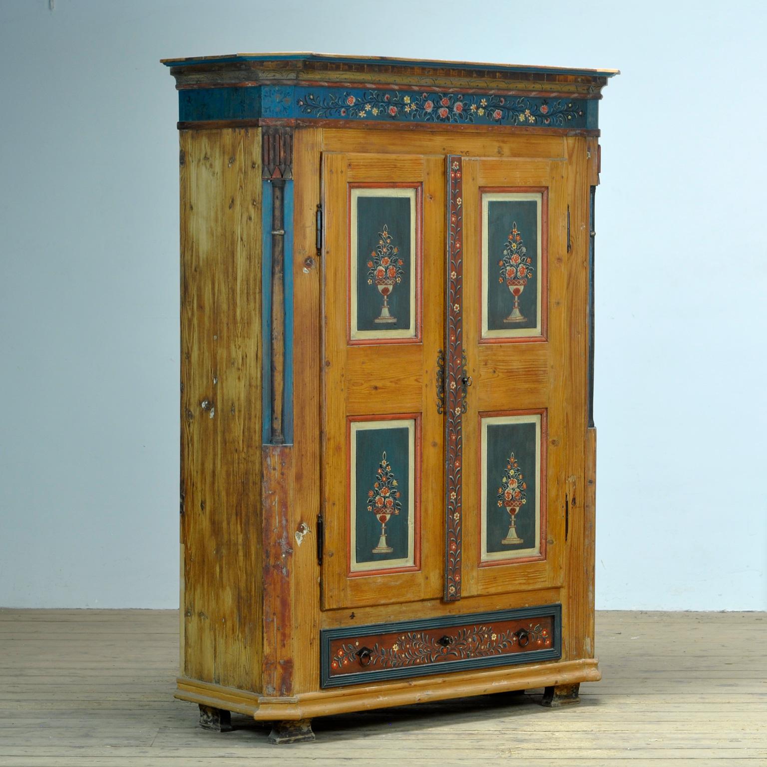 A pine cupboard from rural southern Germany, dating from around 1850. The cupboard was probably given as a wedding gift. This cabinet is made of solid pine and is hand-painted in vibrant colors. On the inside there are 3 shelves on the right and a