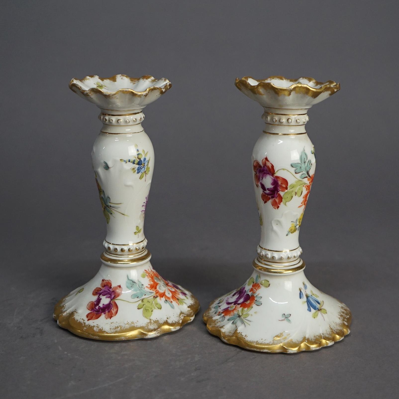An antique German pair of candlesticks offer porcelain construction with hand painted floral decoration and gilt highlights throughout, Berlin stamped on bases as photographed, c1900

Measures- 7.25''H x 4.25''W x 4.5''D.
