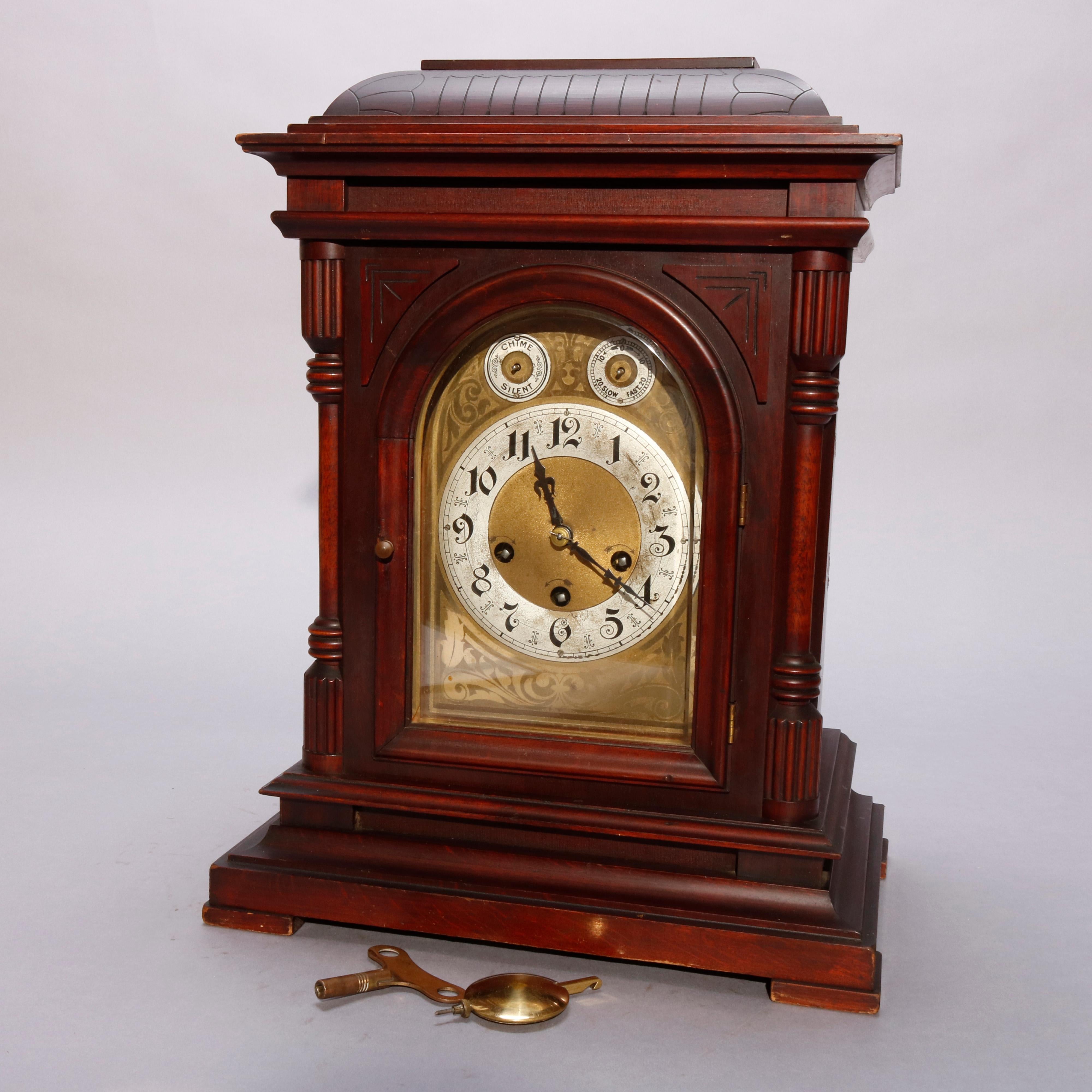 An antique German Junghan bracket clock offers mahogany case with incised domed top surmounting paneled case having arched face with flanking balustrade supports, raised on stepped base, with key, circa 1910.

Measures: 17.75