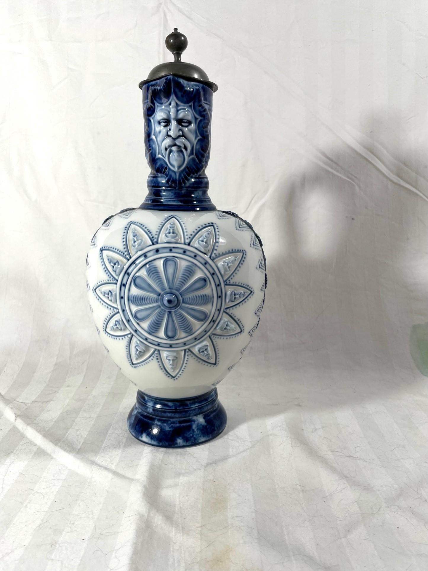 Antique German KPM Porcelain Lidded Bartmann Jug Tankard.

19th century German Bellarmine Bartmann jug with bearded man from the Porcelain Manufactory KPM Berlin. Jugs like this are also known as narrow necked jugs or German Enghalskrug. It has a