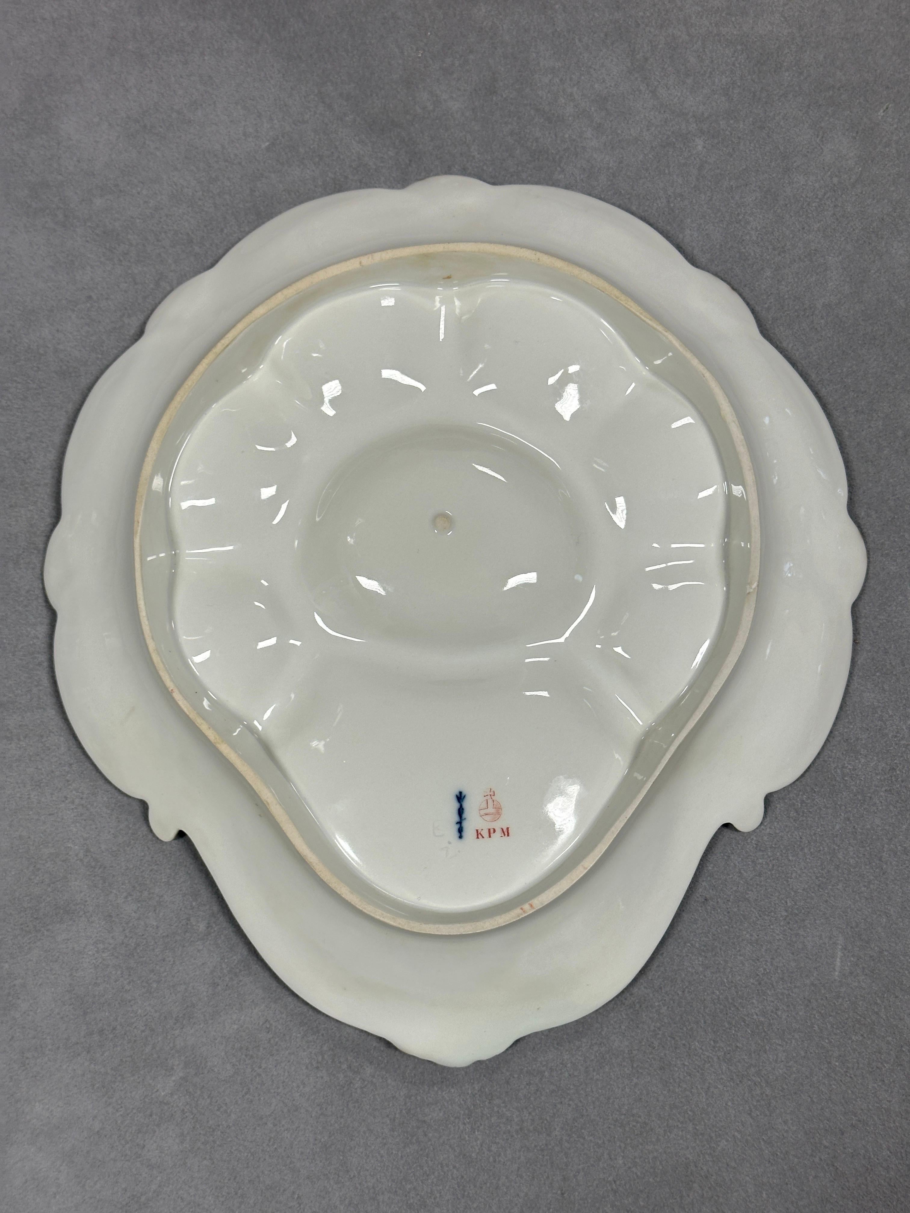 Antiguo plato de ostras de porcelana alemana KPM Royal Berlin pintado a mano con seis pocillos.

La fábrica KPM Royal Porcelain, famosa por producir porcelana fina desde el siglo XVIII, es muy apreciada por su artesanía y su importancia histórica,