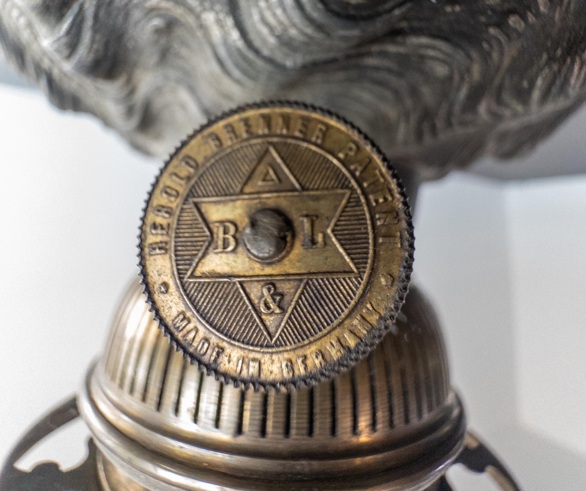 Exquisita lámpara de aceite antigua con el famoso quemador Herold, fabricada por Brendel & Löwig de Berlín, Alemania, hacia 1900. La ornamentada base de esqueleto está ricamente decorada con dos putti finamente modelados, rodeados de un detallado
