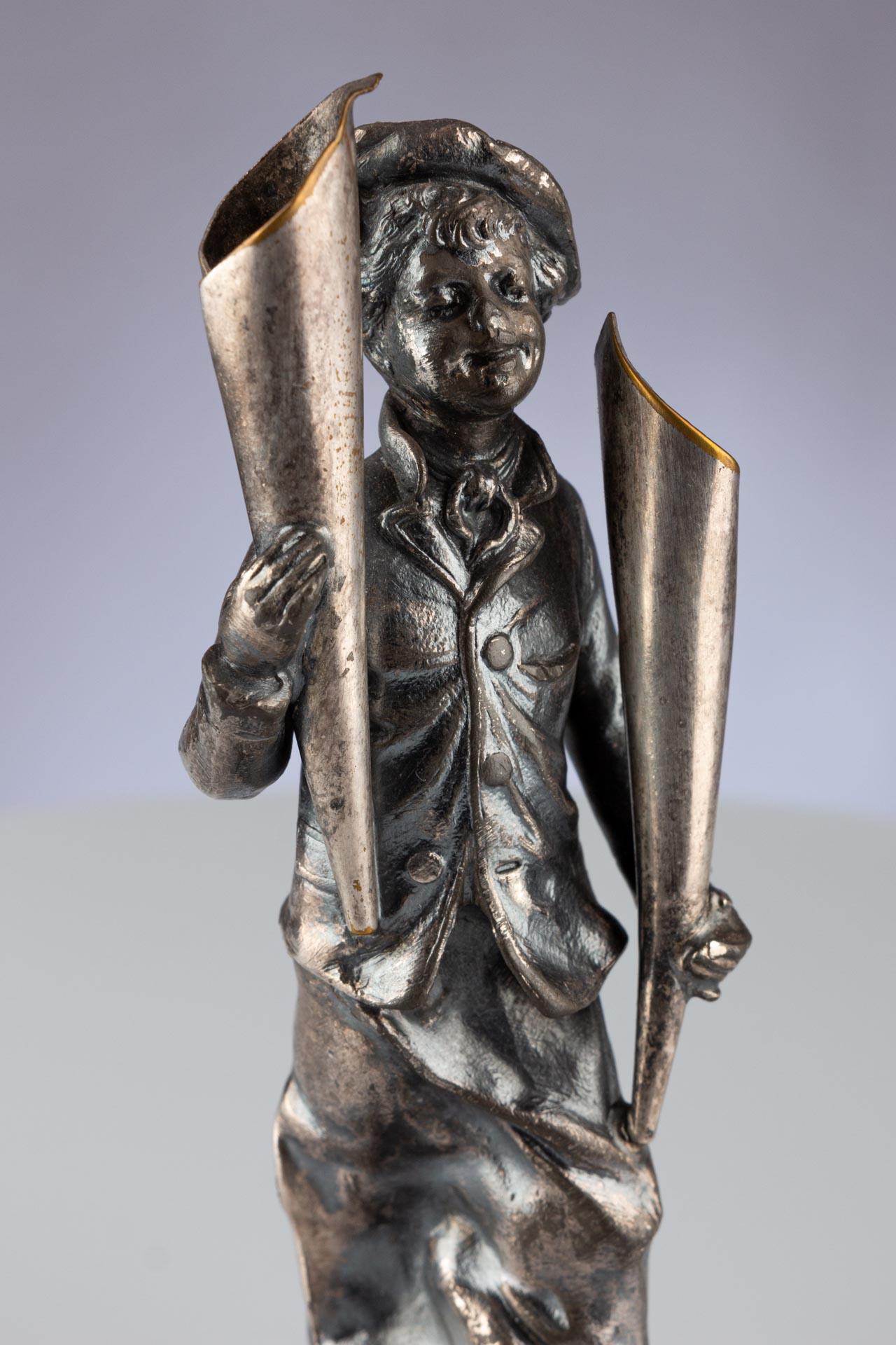 Diese bezaubernde antike Skulptur wurde von der WMF, kurz für Württembergische Metallwarenfabrik, hergestellt, einem renommierten deutschen Hersteller feiner Metallwaren, der 1853 gegründet wurde und noch heute in Betrieb ist. WMF ist zwar vor allem