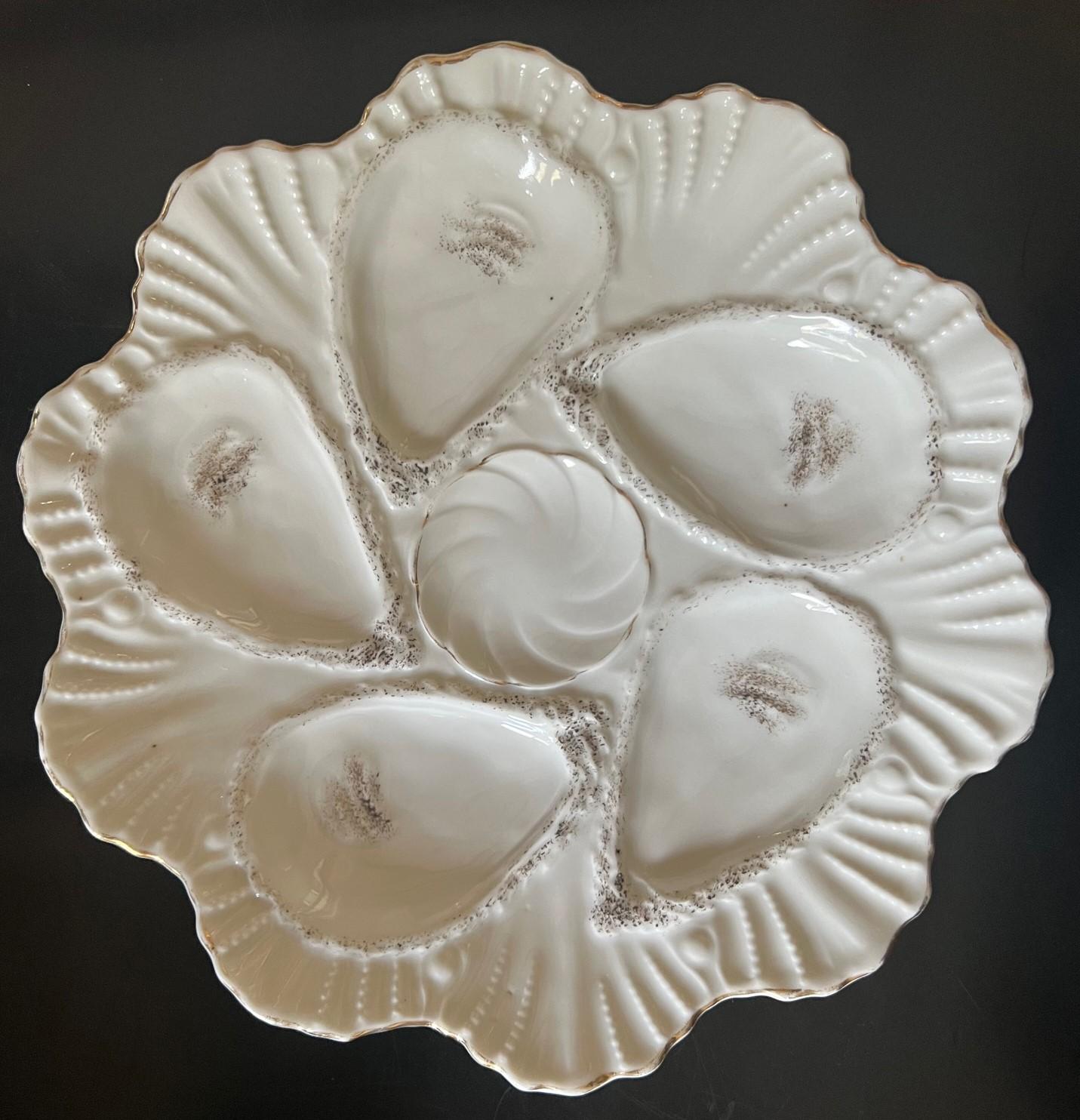 Antique oyster plates made in Germany in the mid to late 1800's. The plate has five wells with a center well for lemons, They all have an impressed Registrirt mark on the back as well as a hand painted number.