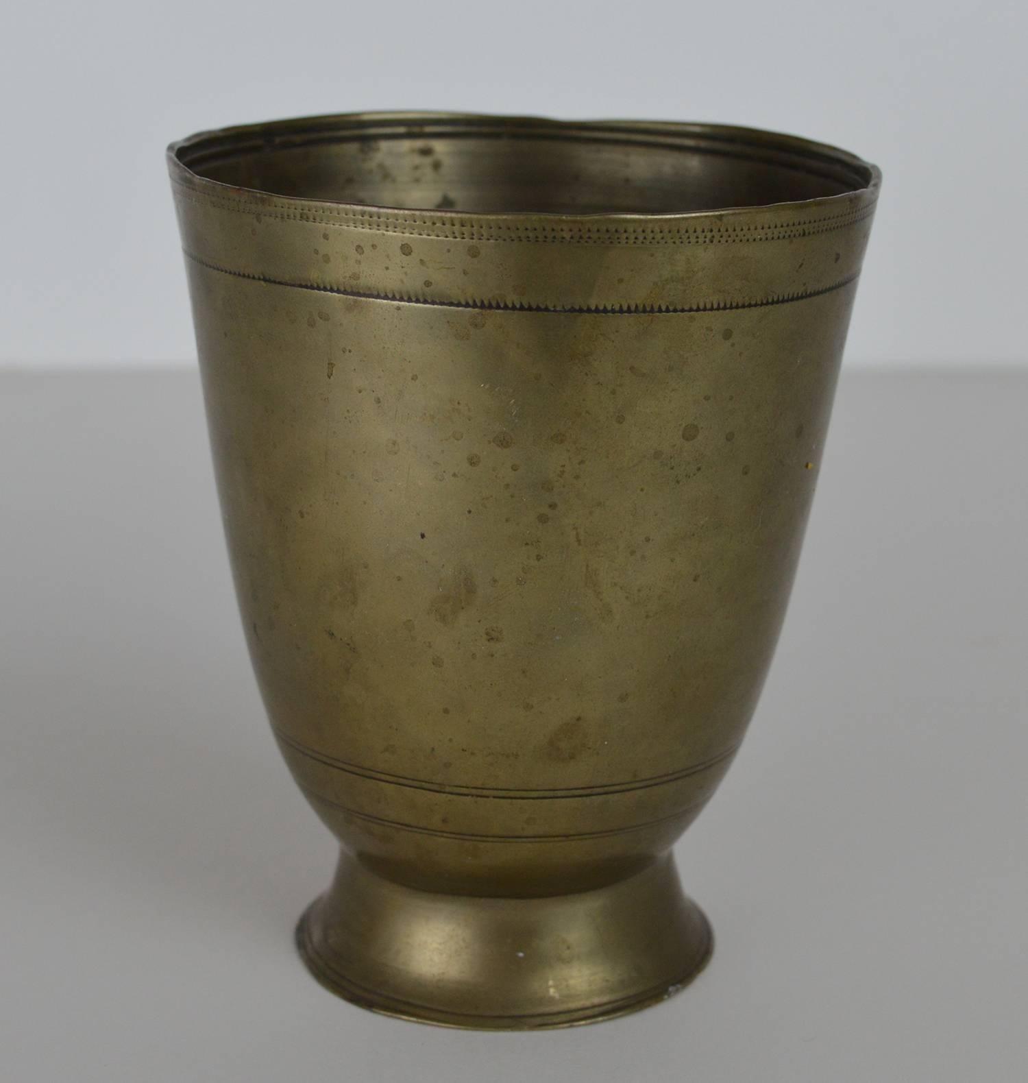 This fine antique tumbler cup has a plain circular form.

Made from the rare and highly prized metal Paktong.

Similar in shape to silver examples of the same period.

The surface of this antique cup is embellished with three bands of tooled