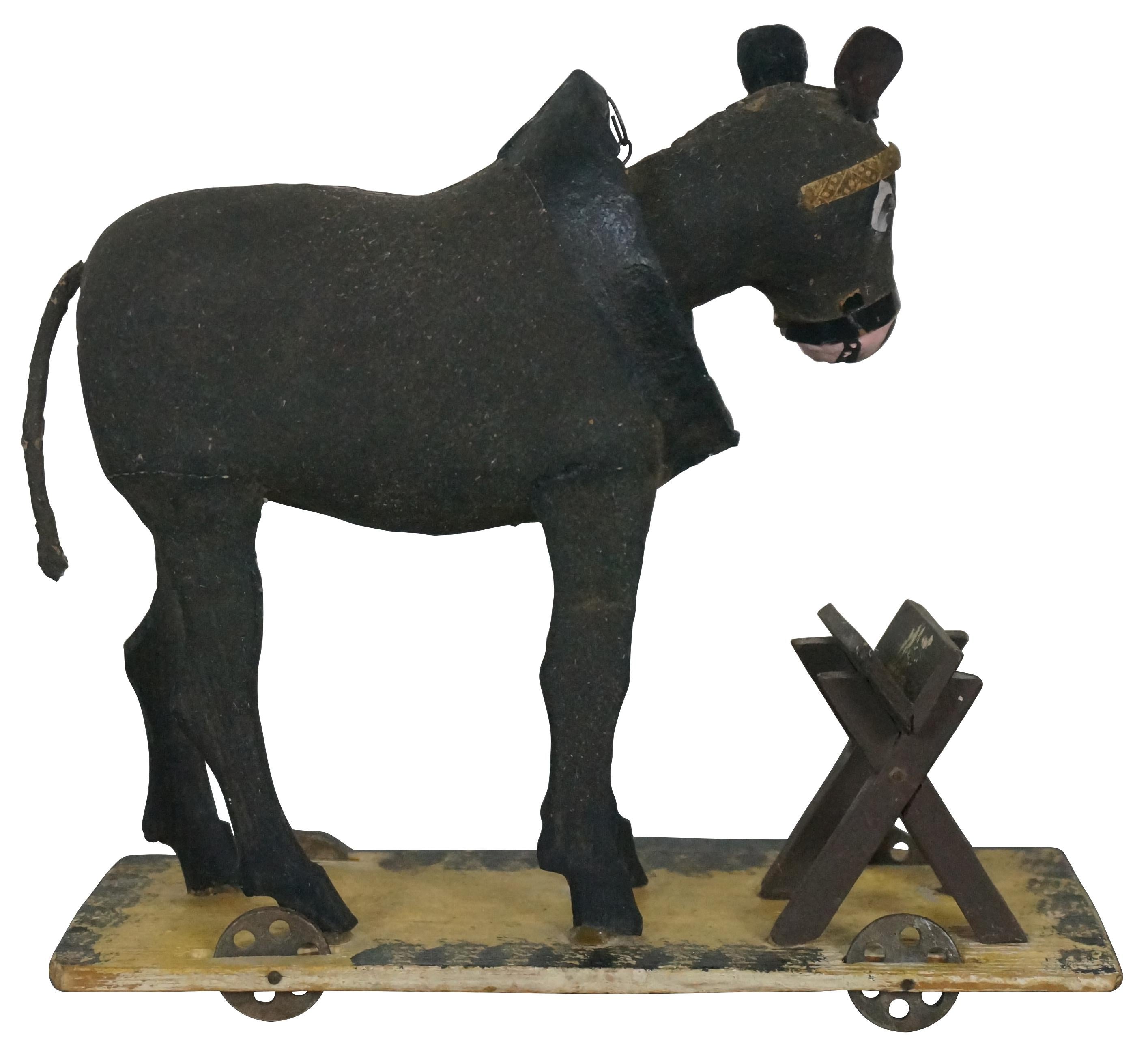Rare antique German paper mache composition bobble head mule / donkey / horse pull toy figure standing with a small feed manger on a platform rolling cart. Size: 7.5