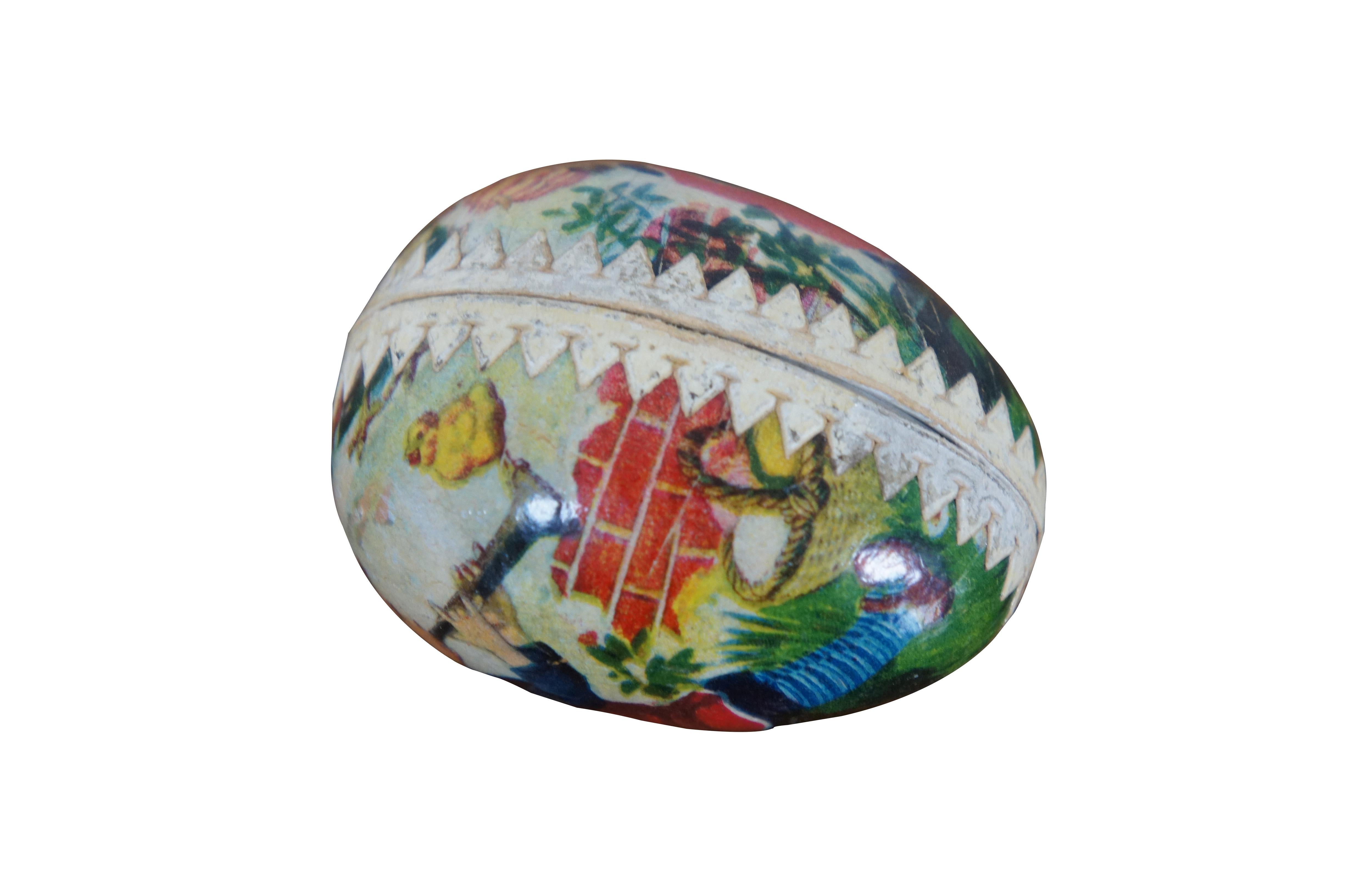 Antique lithographed paper mache Easter egg candy container featuring a boy playing his trumpet with chicks.  Made in Germany.

Dimensions:
2.25” x 1.5” x 1.75” (Width x Depth x Height)