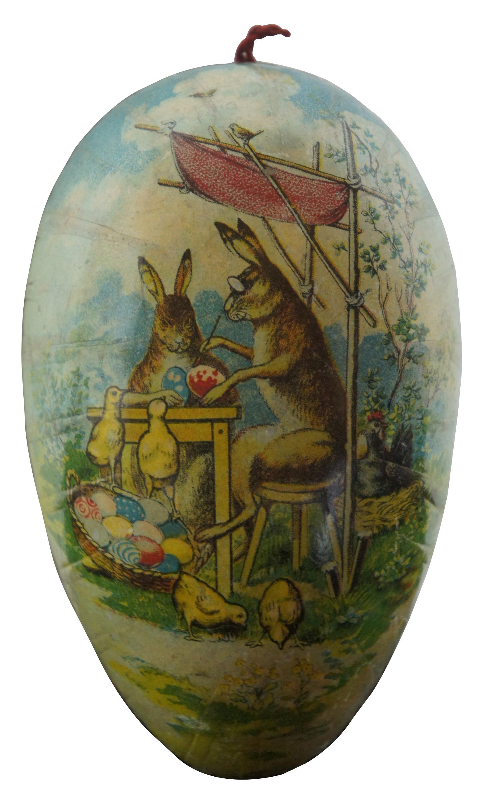 Antique German papier mâché Easter egg candy container, featuring lithograph scenes of a rooster and hen with chicks on one side and rabbits painting Easter eggs on the other. Measure: 5.5