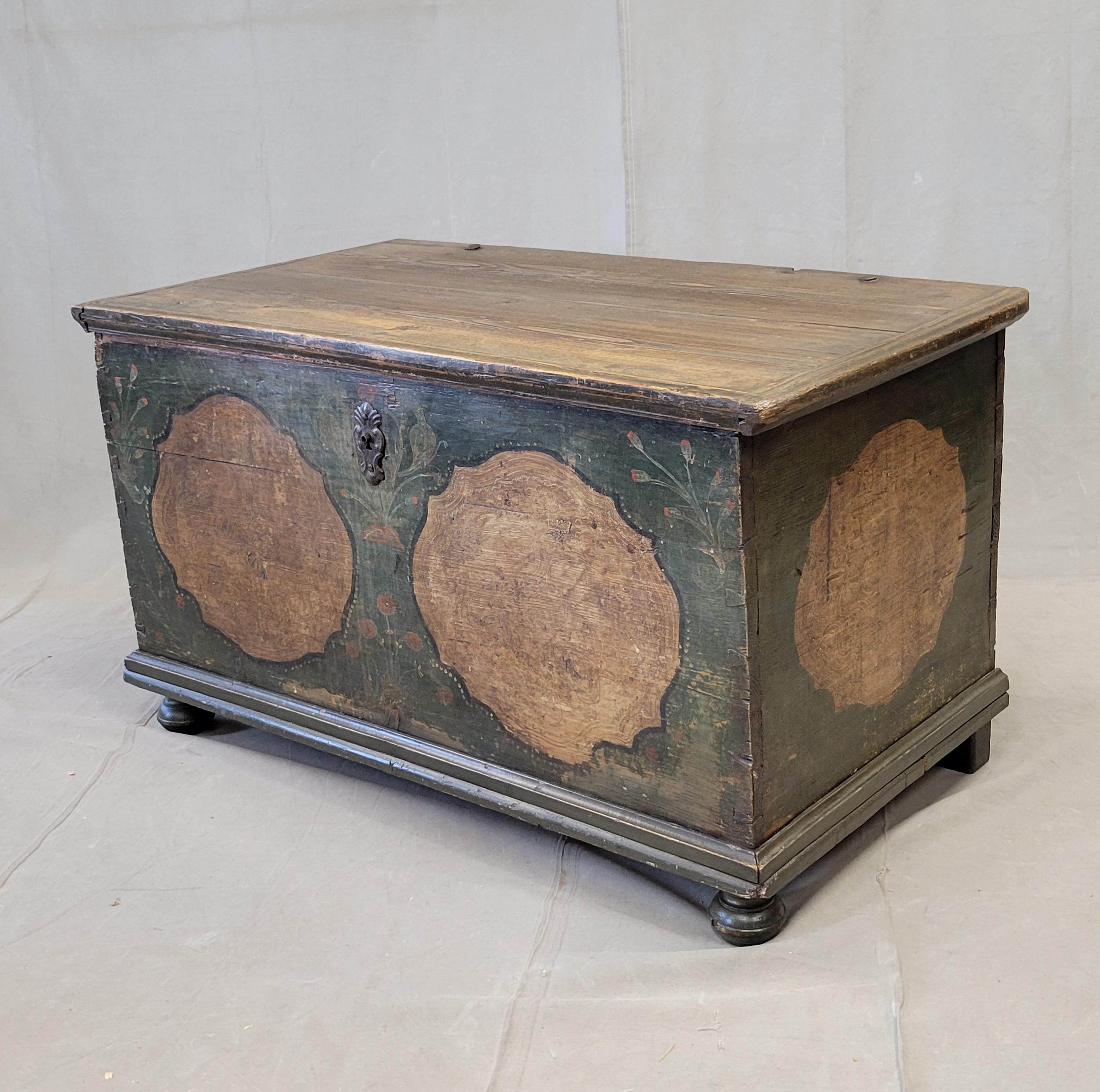 Ancien coffre à couvertures en pin de la fin du 19e siècle, allemand ou d'Europe de l'Est, avec peinture d'origine. Magnifiquement peint à la main de fleurs rouges et bleues et de médaillons de couleur havane  sur fond vert/bleu. L'écusson de la clé