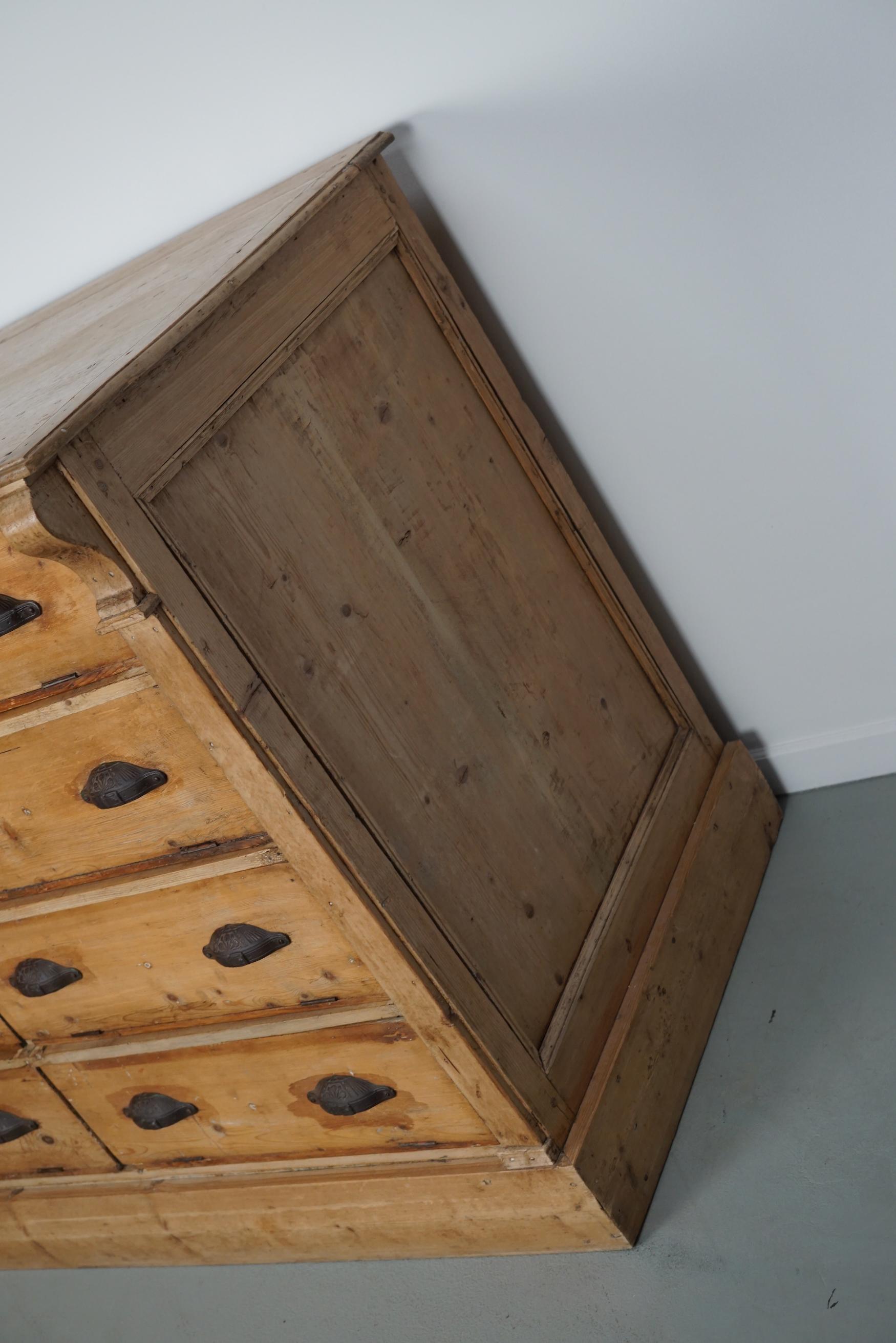 This cabinet was produced in the early 20th century in Germany. It features 8 large drawers with fold down drawer fronts and ornate cast iron handles. It remains in a good condition with signs of use and age.

The interior dimensions of the drawers