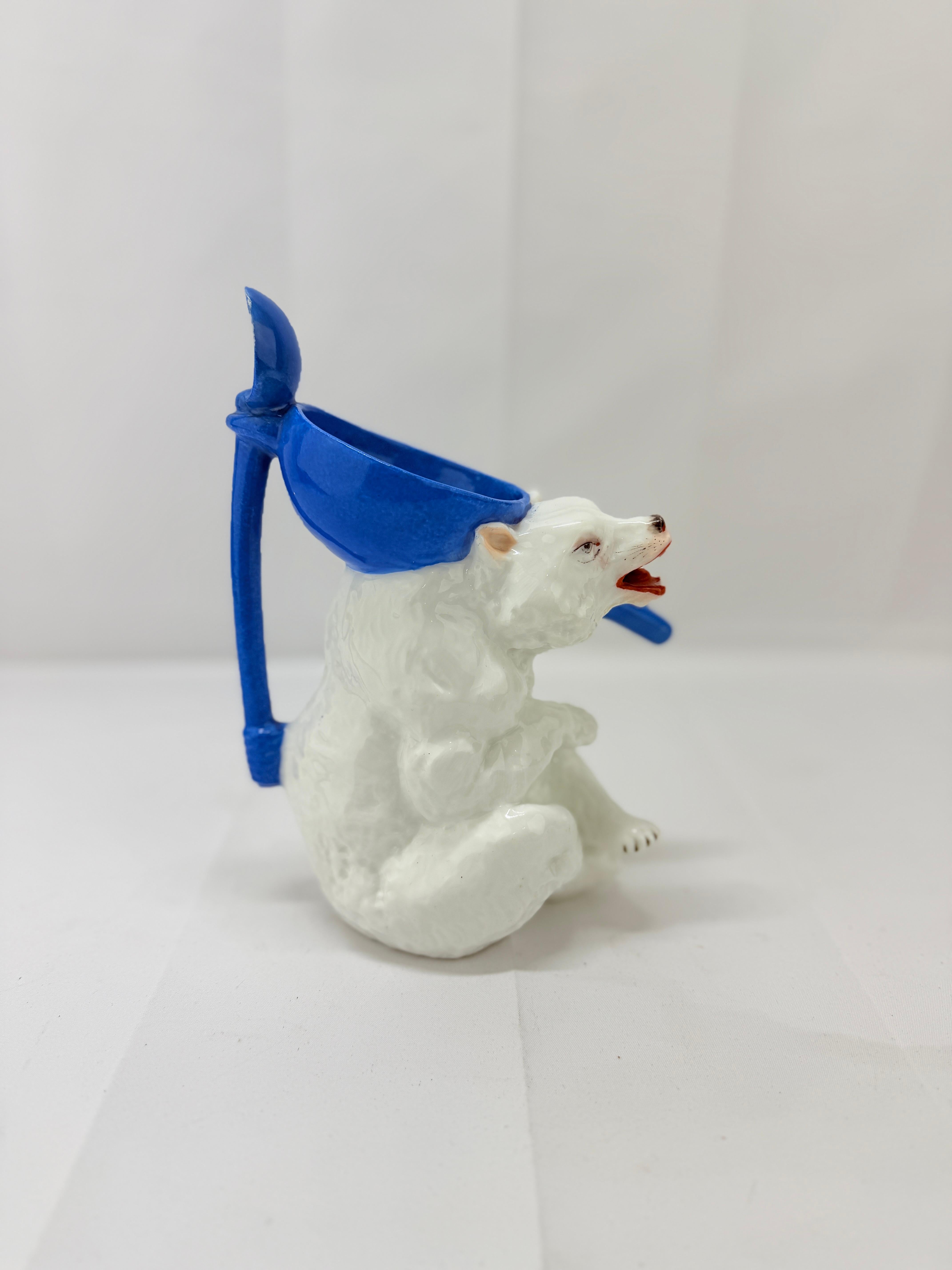 Dieser seltene und skurrile Sirupkrug aus antikem deutschen Porzellan hat die Form eines Eisbären und verkörpert sowohl Charme als auch feine Handwerkskunst. Der Bär ist mit einem grimmigen und ausdrucksstarken Gesicht dargestellt, das dem Stück