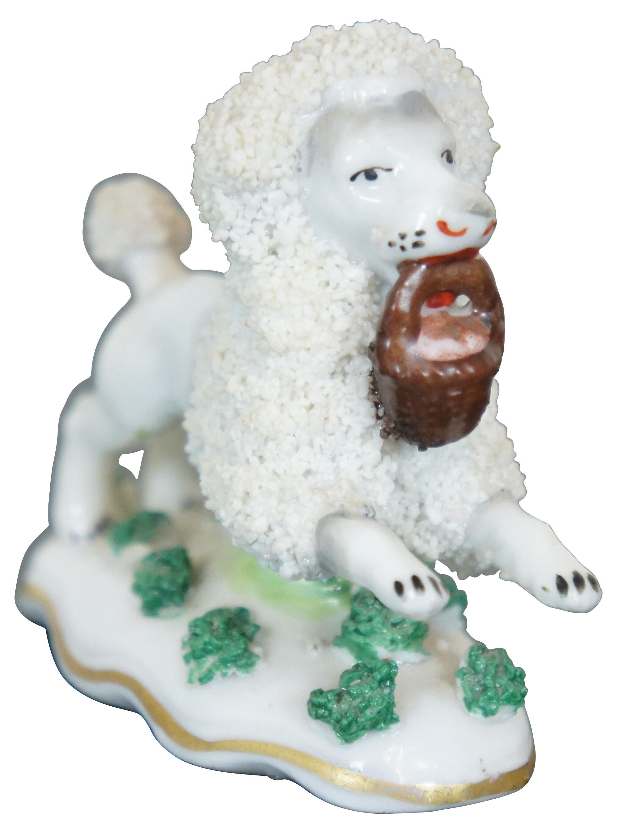 Antique 1885 - 1920s miniature porcelain figurine in the shape a white poodle with confetti fur running with a basket in its mouth. Marked Germany on base opposite a Samson golden anchor. This mark was used on Chelsea Reproductions. Measure : 2.5”.