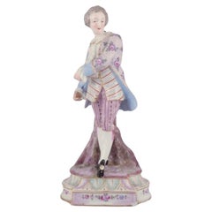 Antique German porcelain figurine of young man in fine clothes.