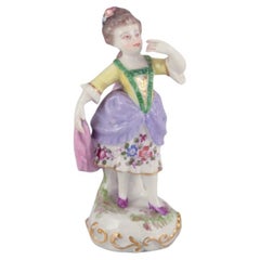 Antique German porcelain figurine. Young woman in elegant attire. 