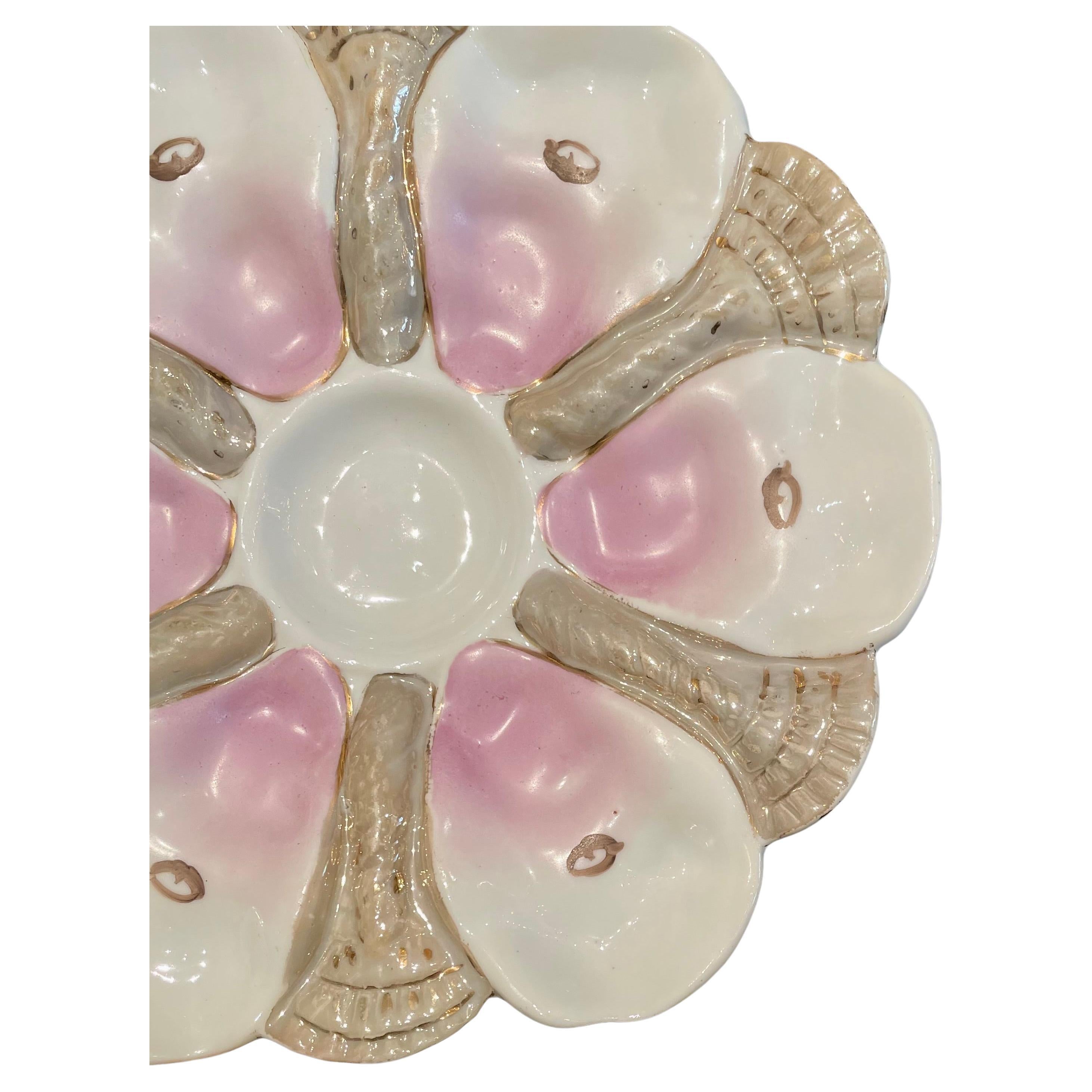 Antique German porcelain oyster plate, circa 1880-1890.
A handsome shaped oyster plate hand painted pink and taupe on a white background.