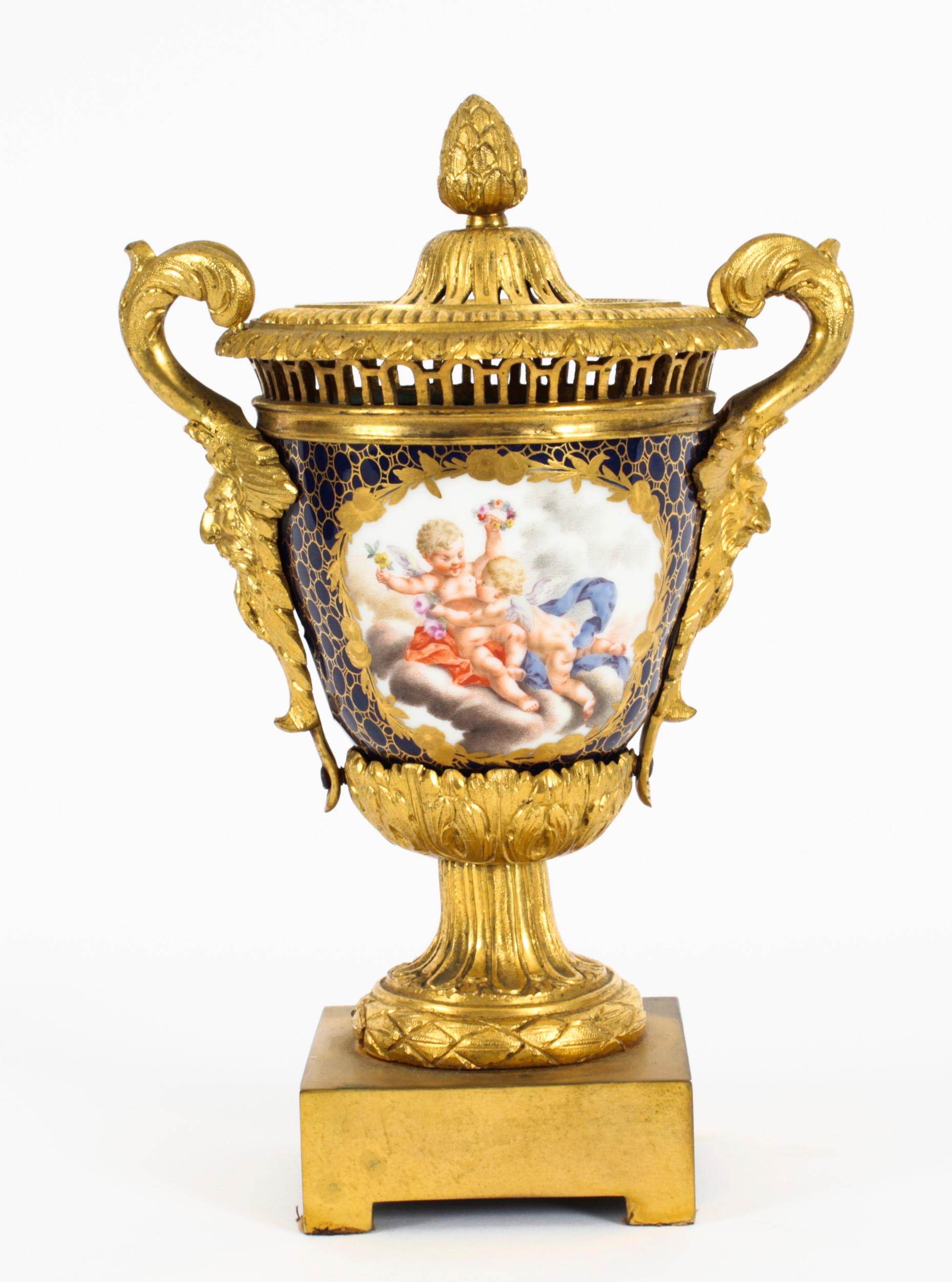 A superb German porcelain ormolu mounted vase, possibly Meissen, Circa 1850 in date.
 
It has ormolu masque handles with a pierced rim and lid, the lid with an acorn finial. The navy blue body skillfully hand painted with playful cherubs and